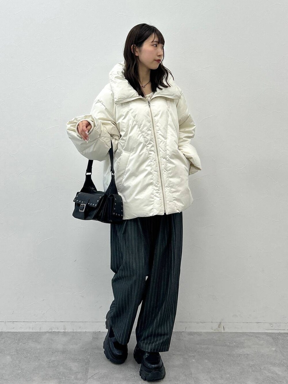 ブラック系のショルダーバッグ、ホワイト系のブルゾン、ホワイト系のTシャツ/カットソーを着用したレディースの秋コーディネートの4枚目の写真