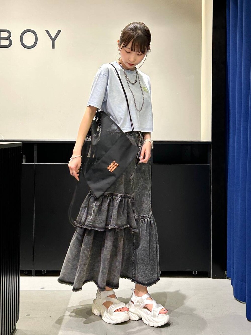 ホワイト系のサンダル、ブラック系のデニムスカート、ブルー系のTシャツ/カットソーを着用したレディースの春コーディネートの3枚目の写真