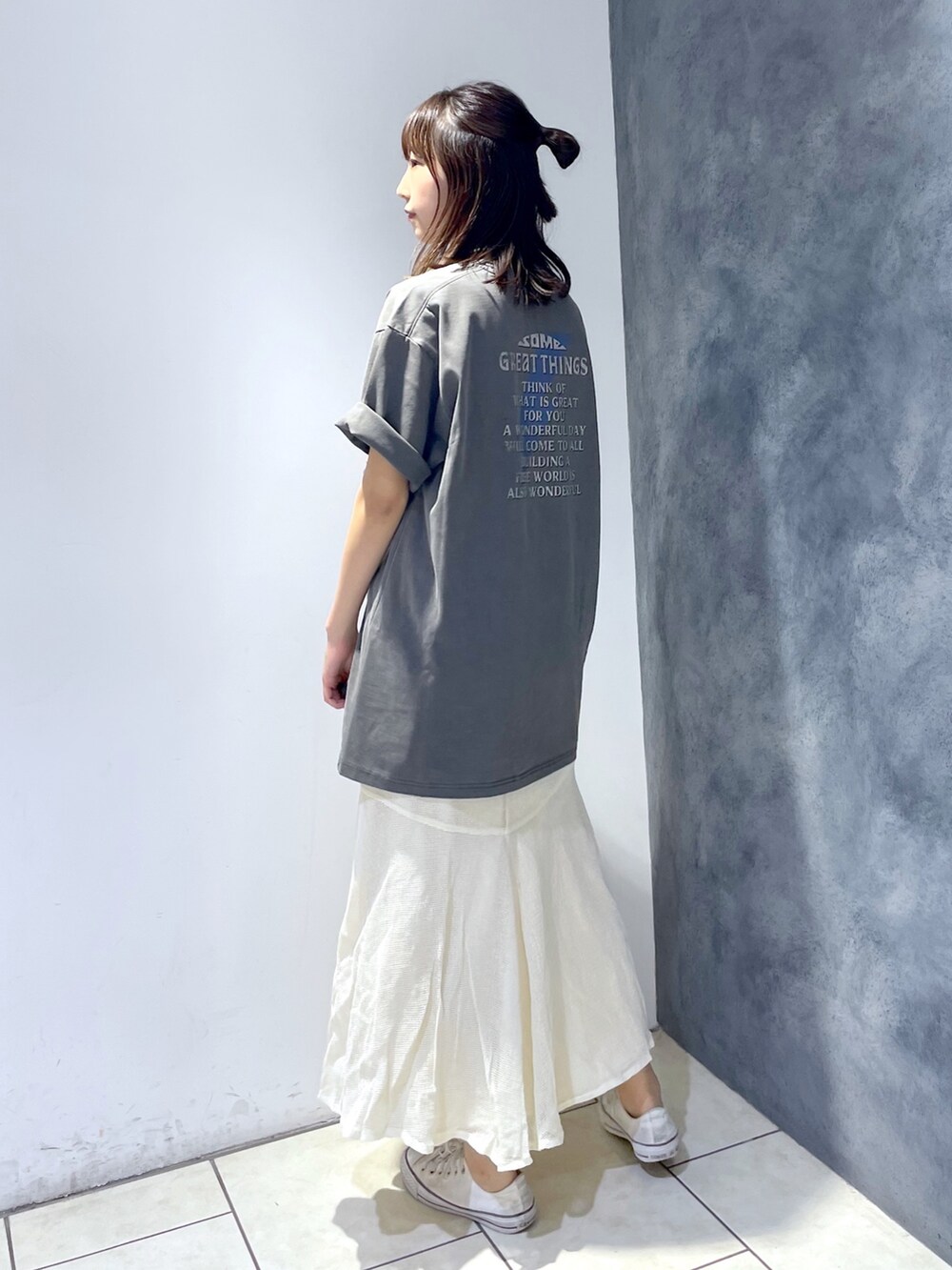 グレー系のTシャツ/カットソー、ホワイト系のスカート、ブラック系のバッグを着用したレディースの春コーディネートの3枚目の写真