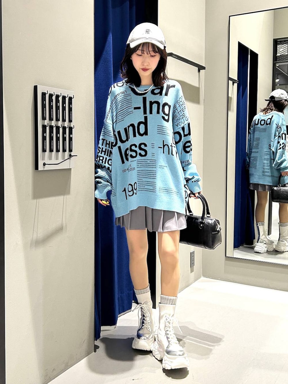 ホワイト系のブーツ、グレー系のその他パンツ、ブラック系のボストンバッグを着用したレディースの冬コーディネートの3枚目の写真