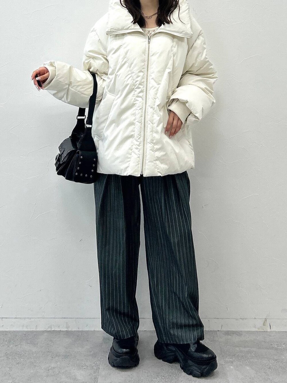 ブラック系のショルダーバッグ、ホワイト系のブルゾン、ホワイト系のTシャツ/カットソーを着用したレディースの秋コーディネートの8枚目の写真