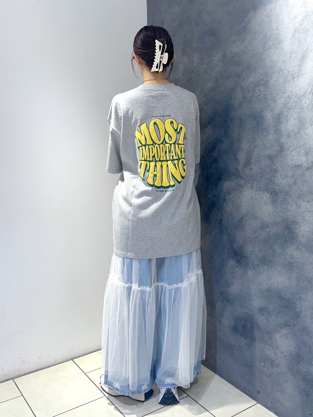 グレー系のTシャツ/カットソー、ホワイト系のワンピース、ブルー系のデニムパンツを着用したレディースの春コーディネートの3枚目の写真