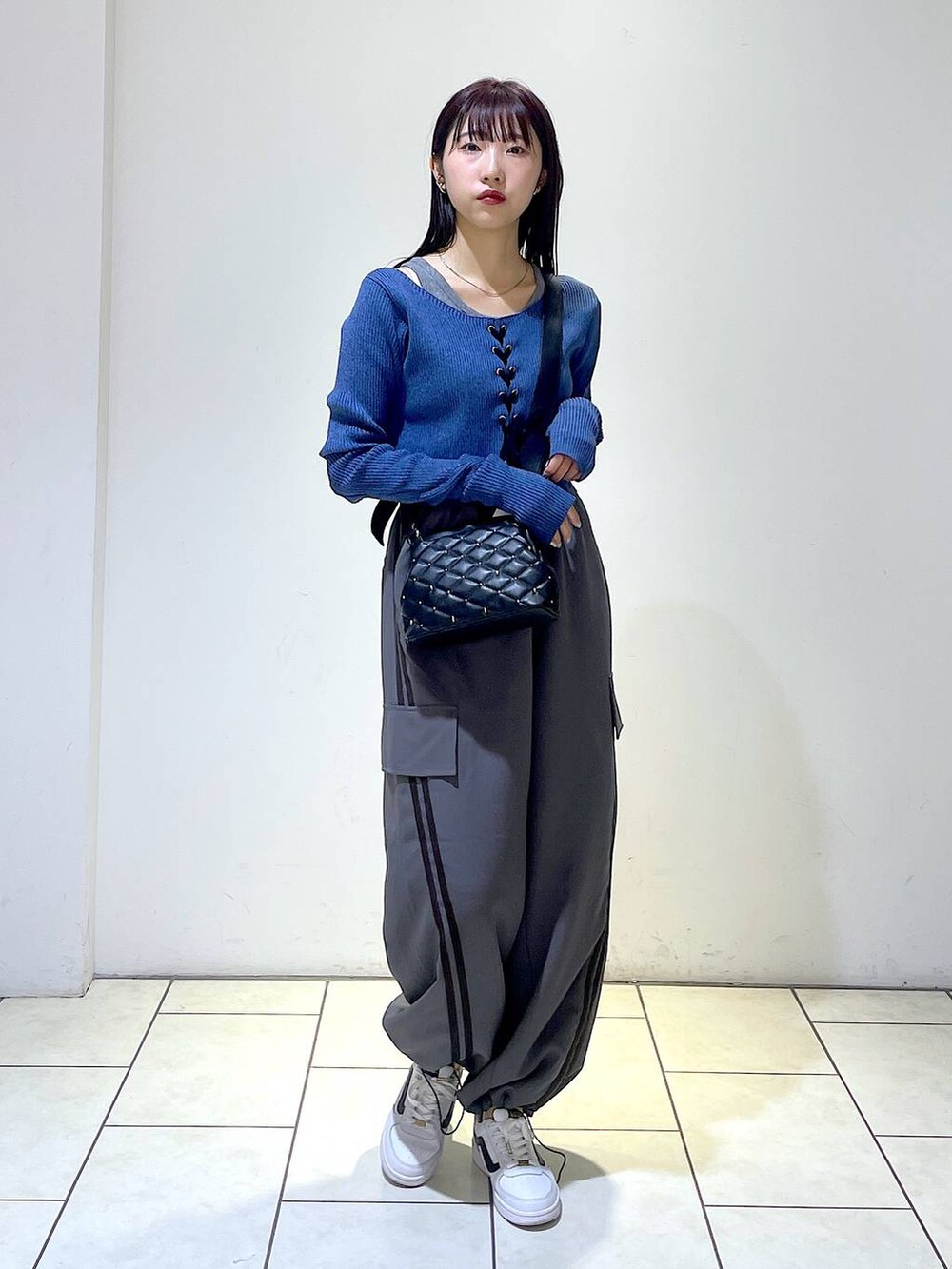 グレー系のその他パンツ、ブラック系のショルダーバッグ、ブルー系のニット/セーターを着用したレディースの冬コーディネートの2枚目の写真