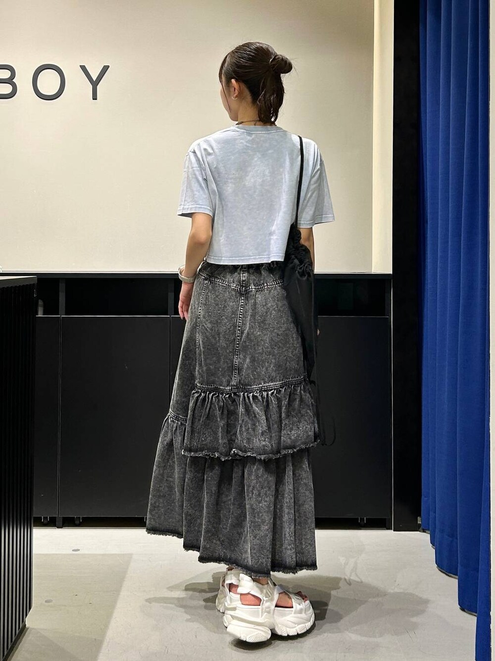 ホワイト系のサンダル、ブラック系のデニムスカート、ブルー系のTシャツ/カットソーを着用したレディースの春コーディネートの6枚目の写真