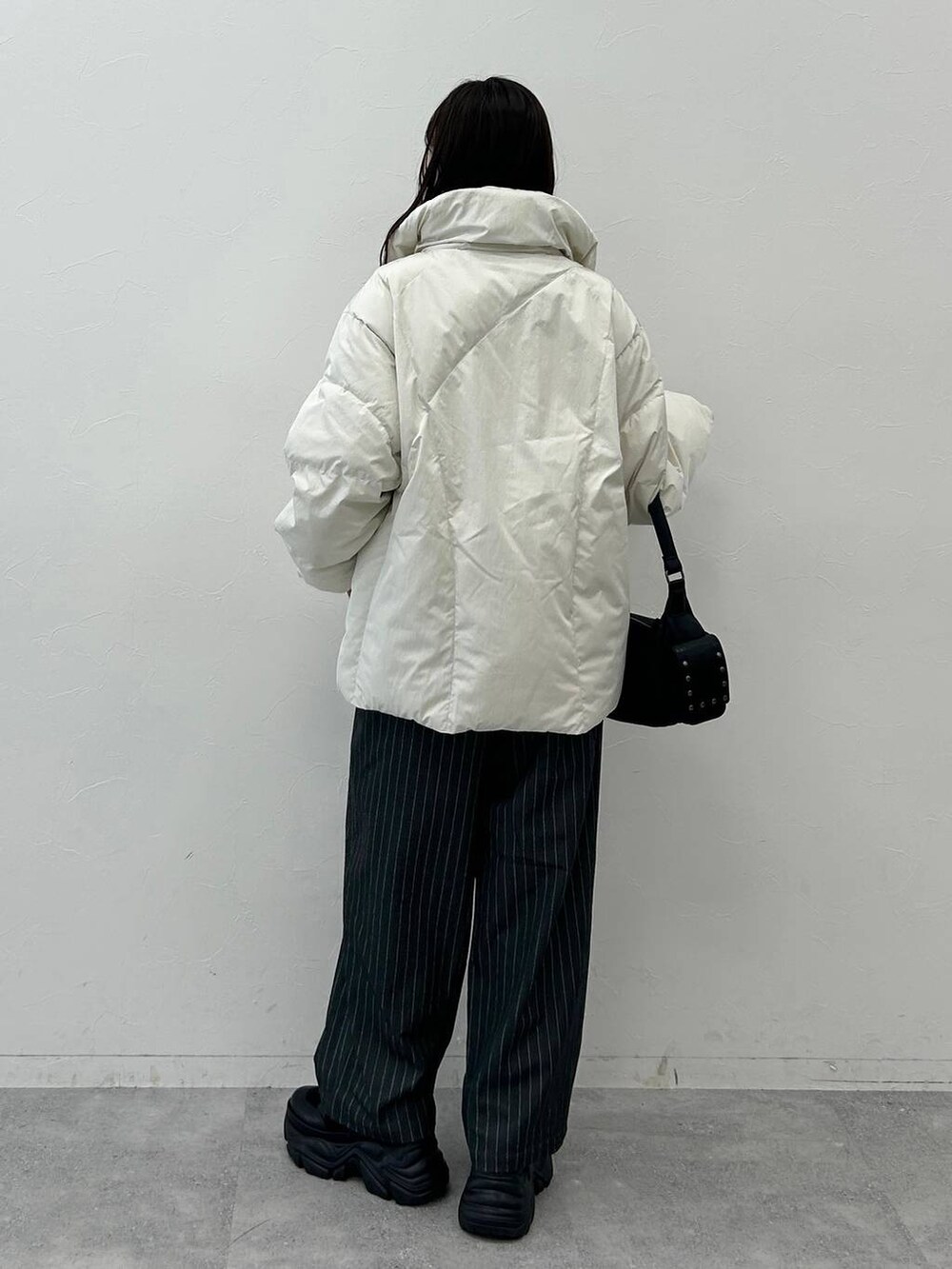 ブラック系のショルダーバッグ、ホワイト系のブルゾン、ホワイト系のTシャツ/カットソーを着用したレディースの秋コーディネートの9枚目の写真