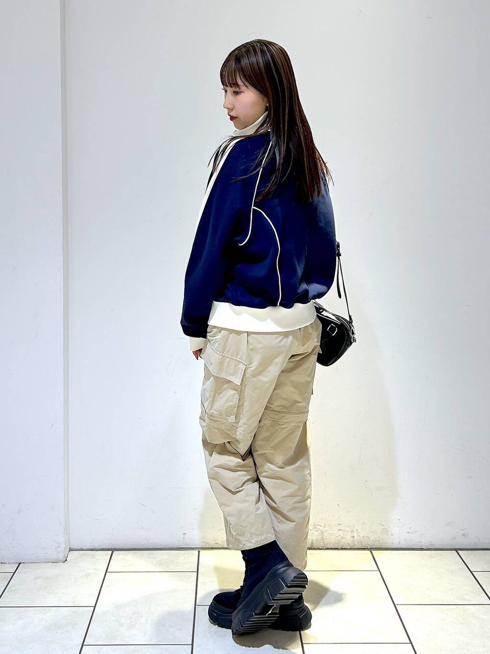 ブルー系のセットアップ、ブラック系のボストンバッグ、ブラック系のブーツを着用したレディースの冬コーディネートの5枚目の写真