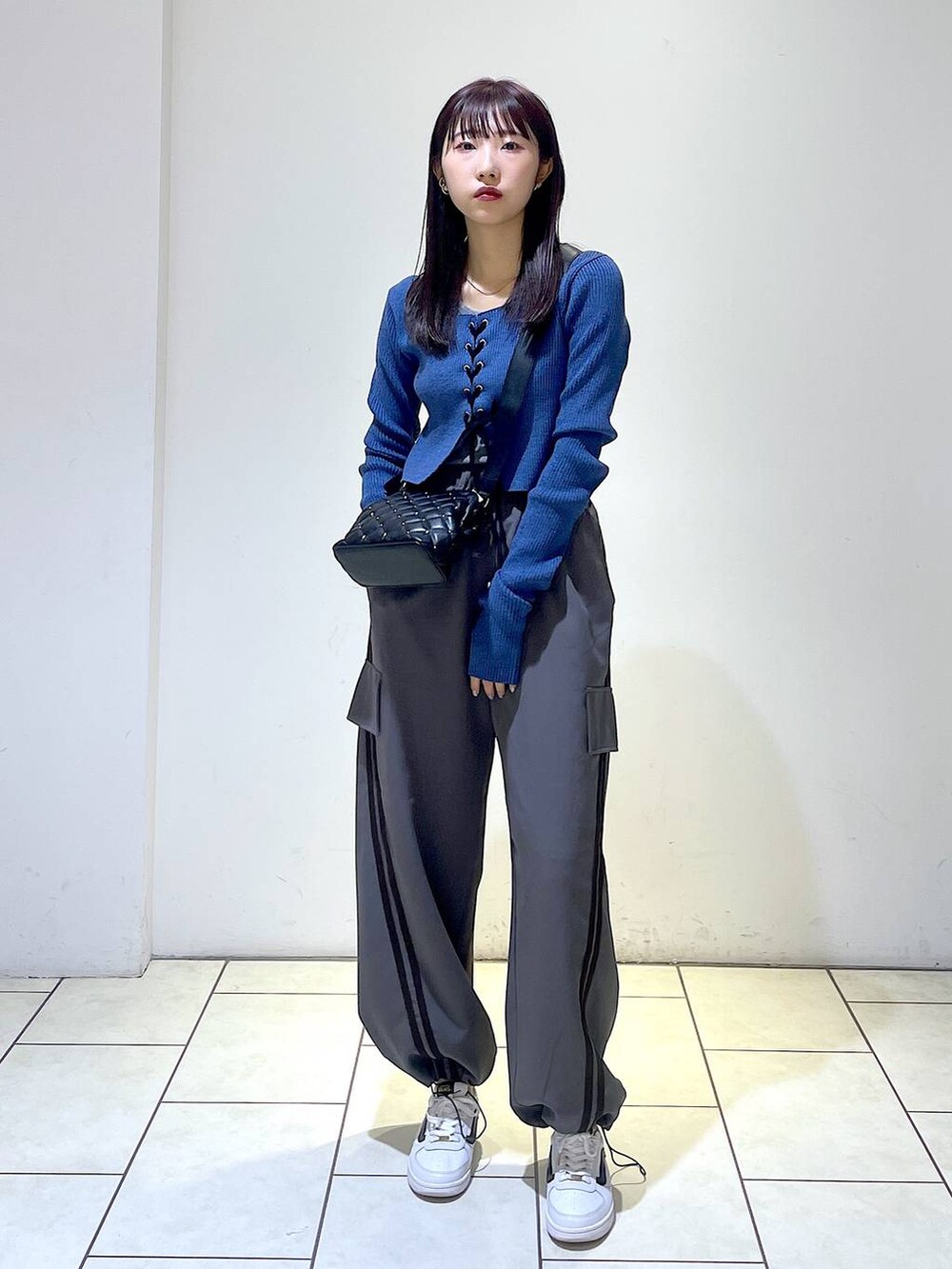 グレー系のその他パンツ、ブラック系のショルダーバッグ、ブルー系のニット/セーターを着用したレディースの冬コーディネートの4枚目の写真