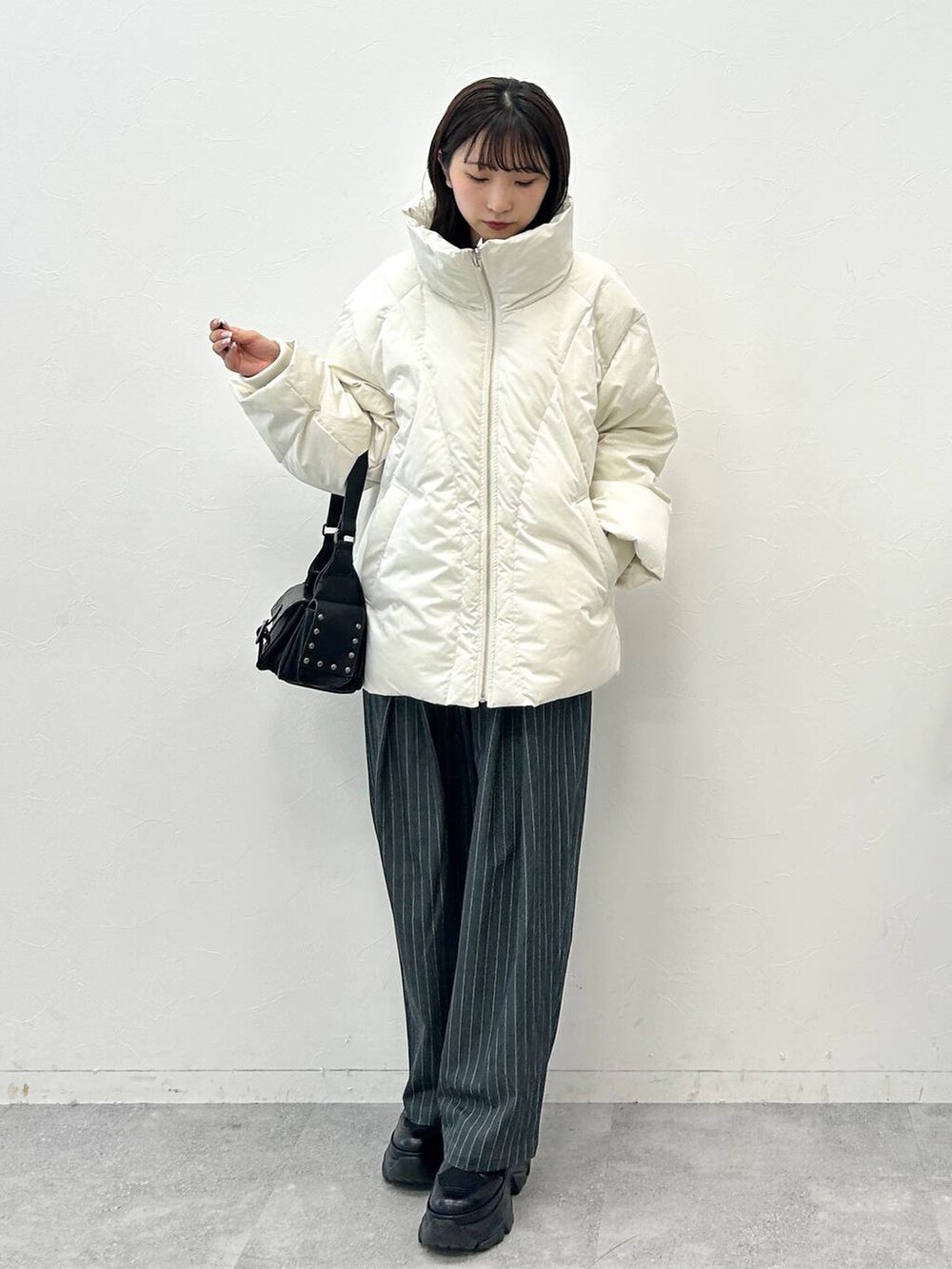 ブラック系のショルダーバッグ、ホワイト系のブルゾン、ホワイト系のTシャツ/カットソーを着用したレディースの秋コーディネートの3枚目の写真