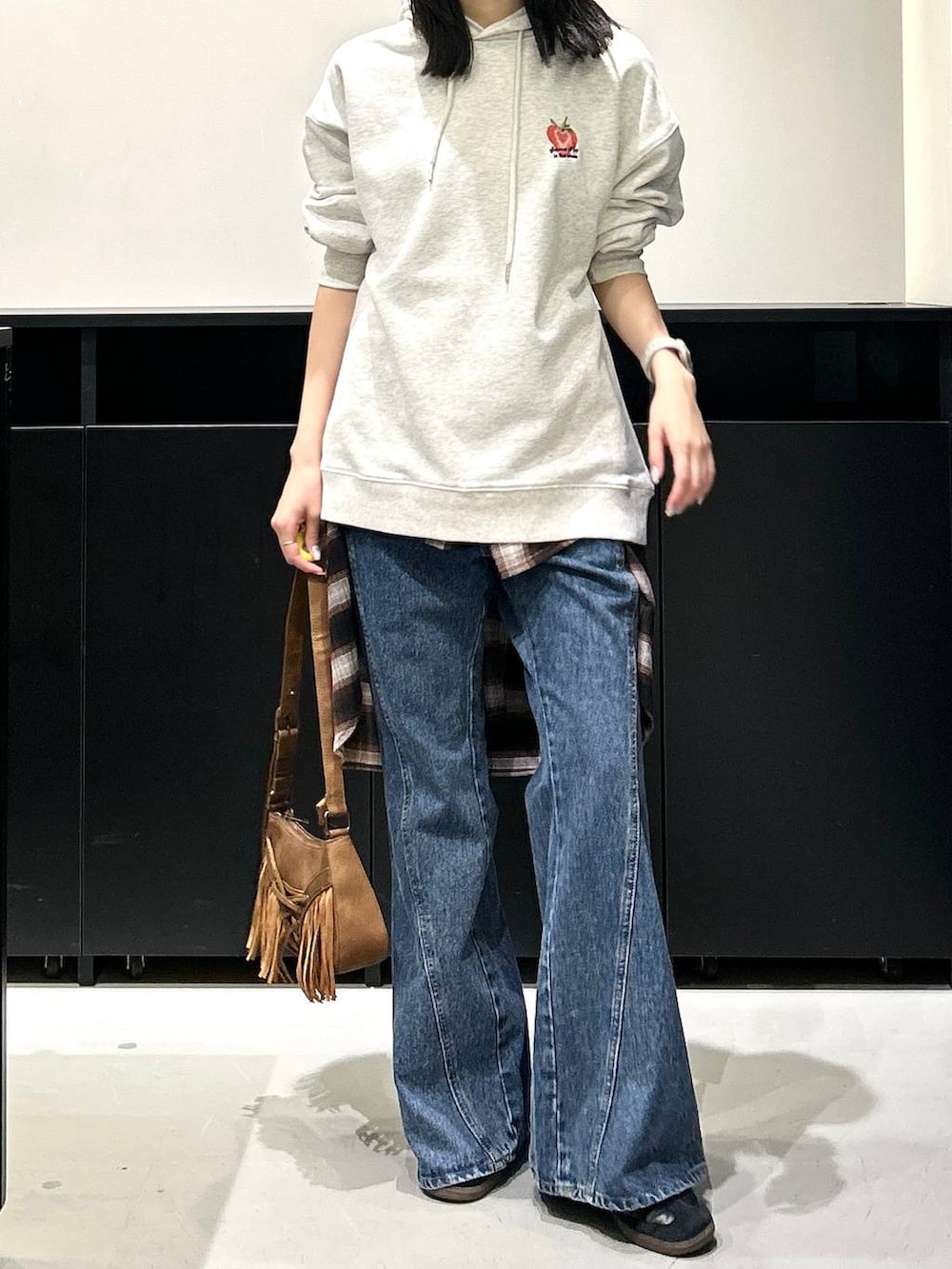 ベージュ系のショルダーバッグ、ブルー系のデニムパンツ、ブラウン系のシャツ/ブラウスを着用したレディースの夏コーディネートの2枚目の写真