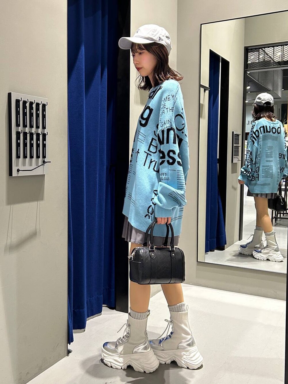 ホワイト系のブーツ、グレー系のその他パンツ、ブラック系のボストンバッグを着用したレディースの冬コーディネートの5枚目の写真