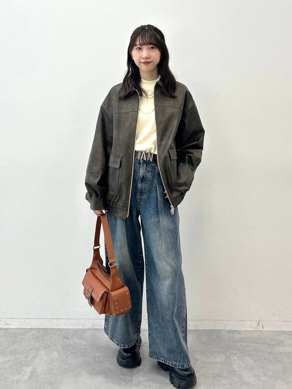 ブラック系のブーツ、ブルー系のデニムパンツ、ホワイト系のニット/セーターを着用したレディースの夏コーディネートの7枚目の写真