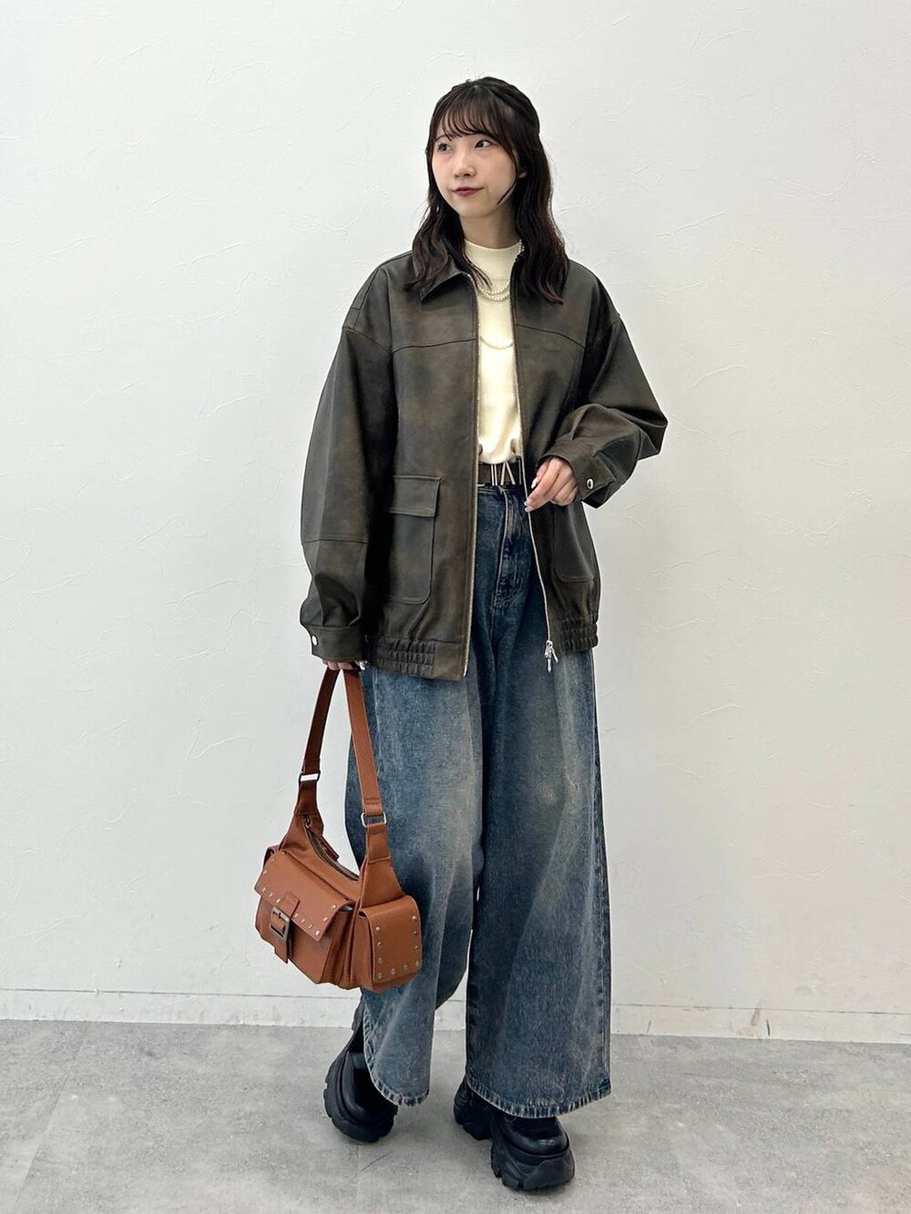 ブラック系のブーツ、ブルー系のデニムパンツ、ホワイト系のニット/セーターを着用したレディースの夏コーディネートの5枚目の写真