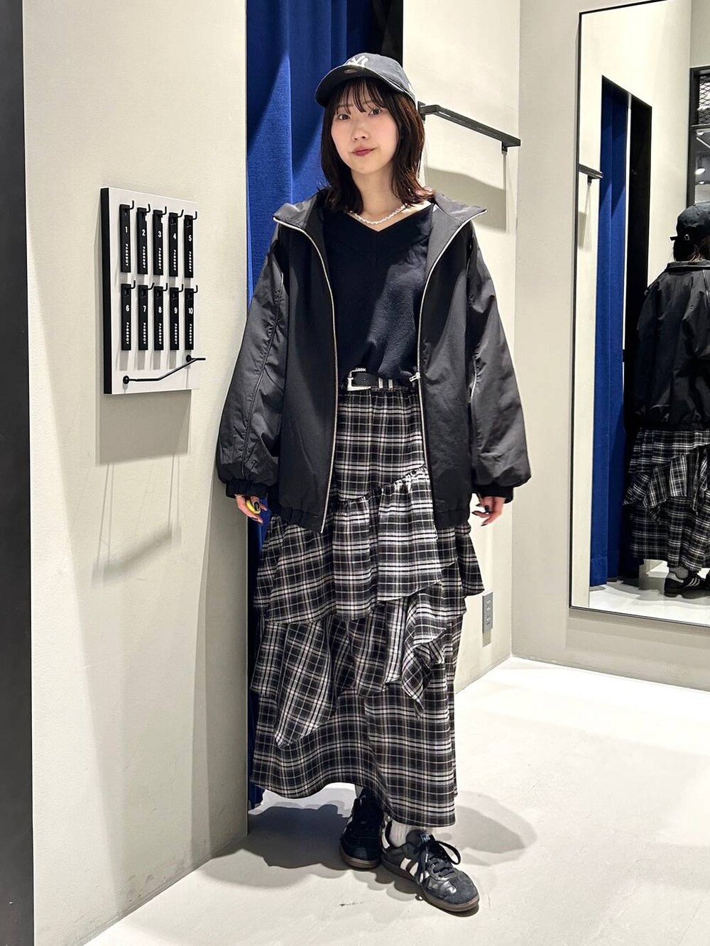 ブラック系のスカート、ブラック系のニット/セーター、ブラック系のナイロンジャケットを着用したレディースの冬コーディネートの2枚目の写真