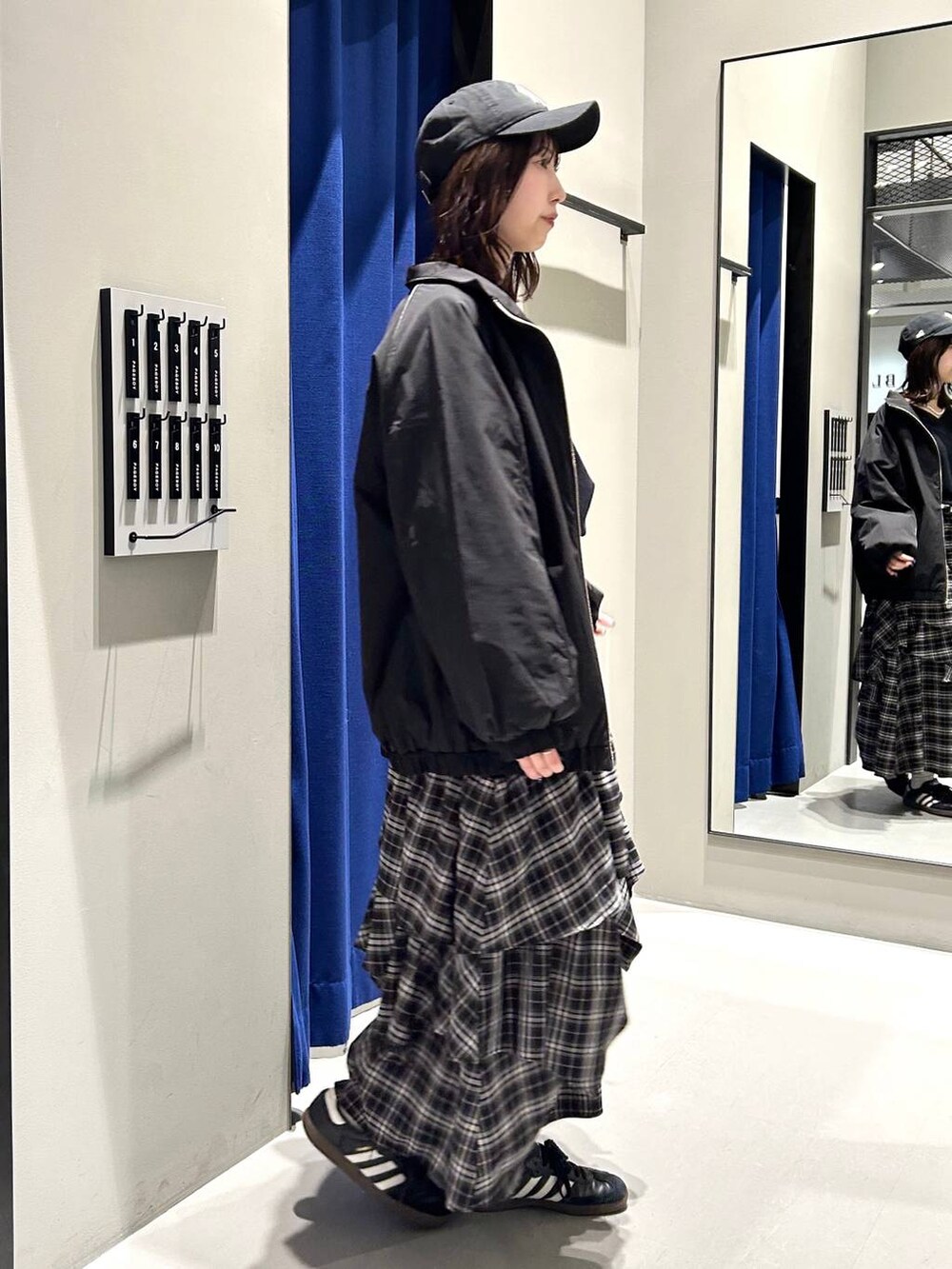 ブラック系のスカート、ブラック系のニット/セーター、ブラック系のナイロンジャケットを着用したレディースの冬コーディネートの6枚目の写真