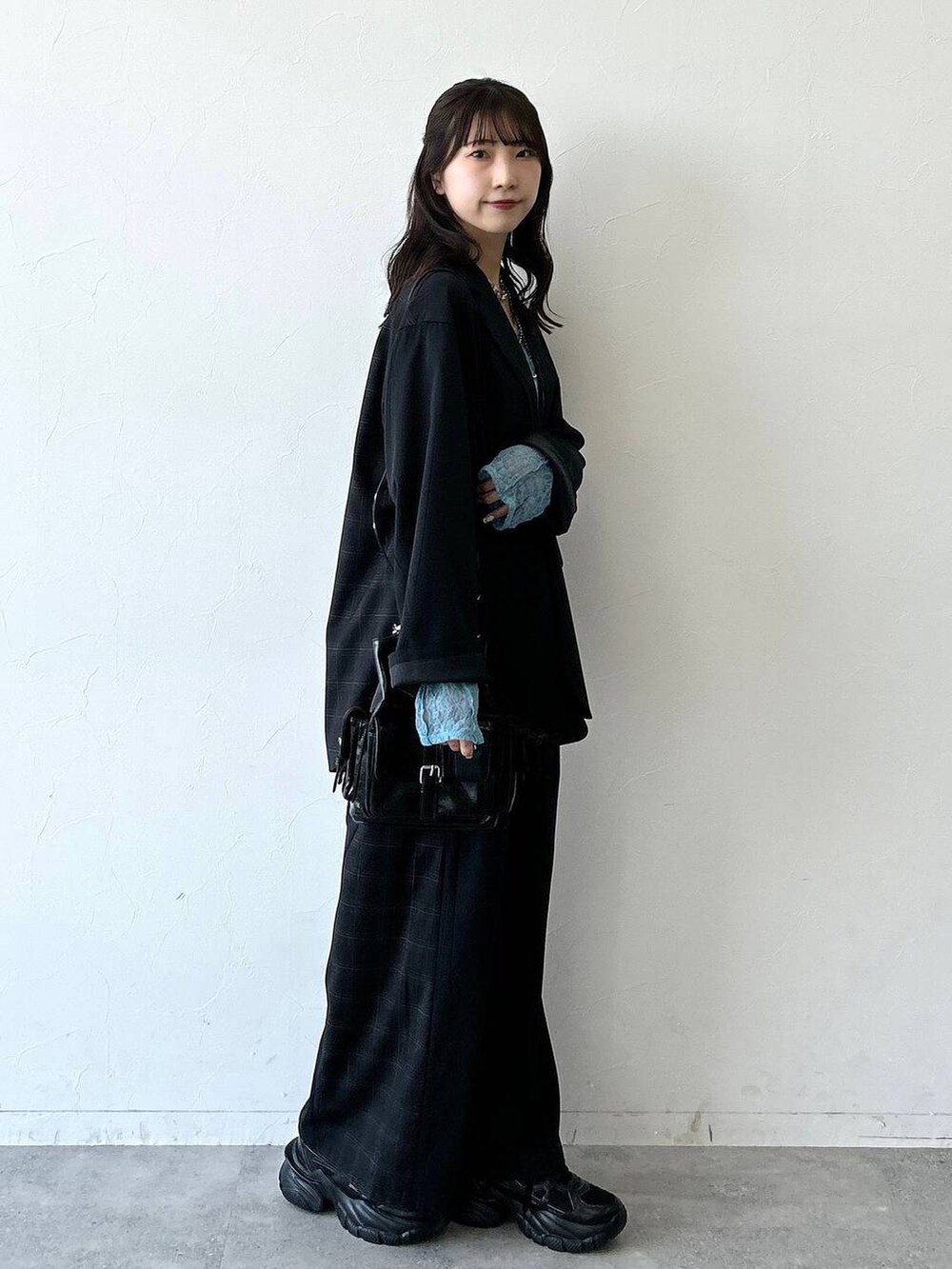 ブラック系のスニーカー、ブラック系のテーラードジャケット、ブラック系のスラックスを着用したレディースの夏コーディネートの6枚目の写真