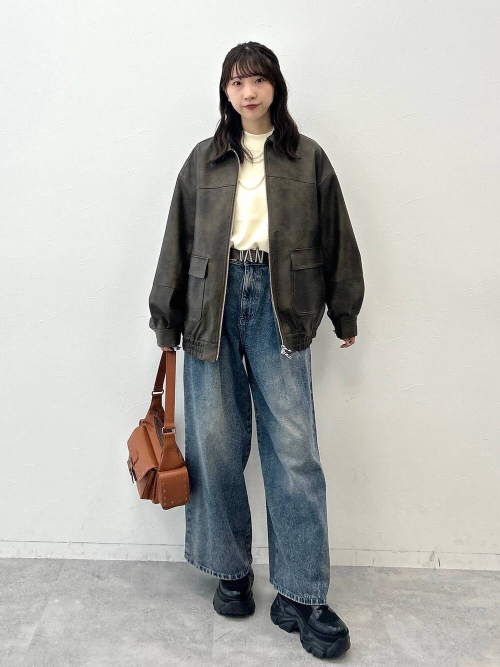 ブラック系のブーツ、ブルー系のデニムパンツ、ホワイト系のニット/セーターを着用したレディースの夏コーディネートの6枚目の写真