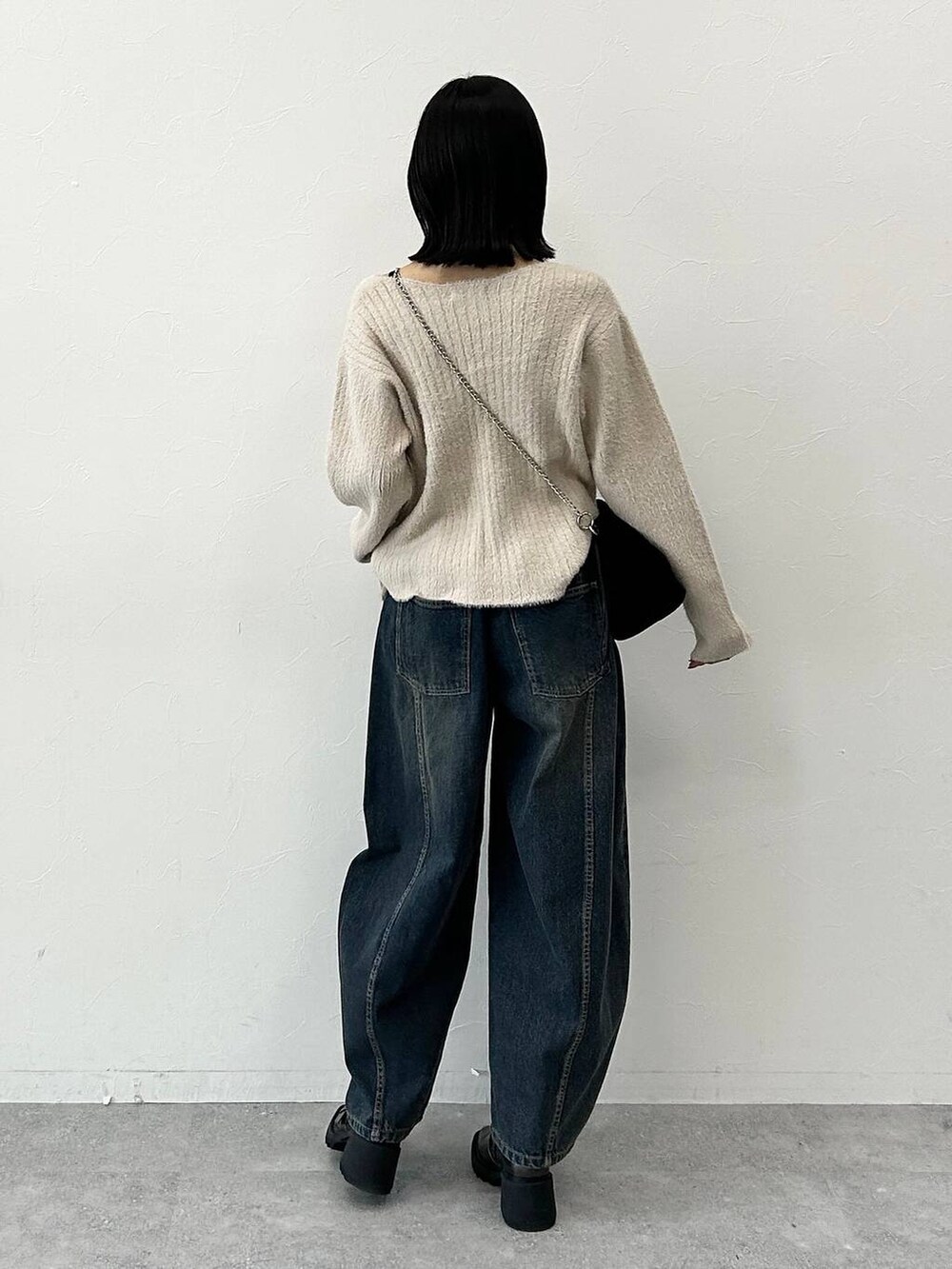 ベージュ系のニット/セーター、その他のブーツ、ブラック系のハンドバッグを着用したレディースの冬コーディネートの6枚目の写真