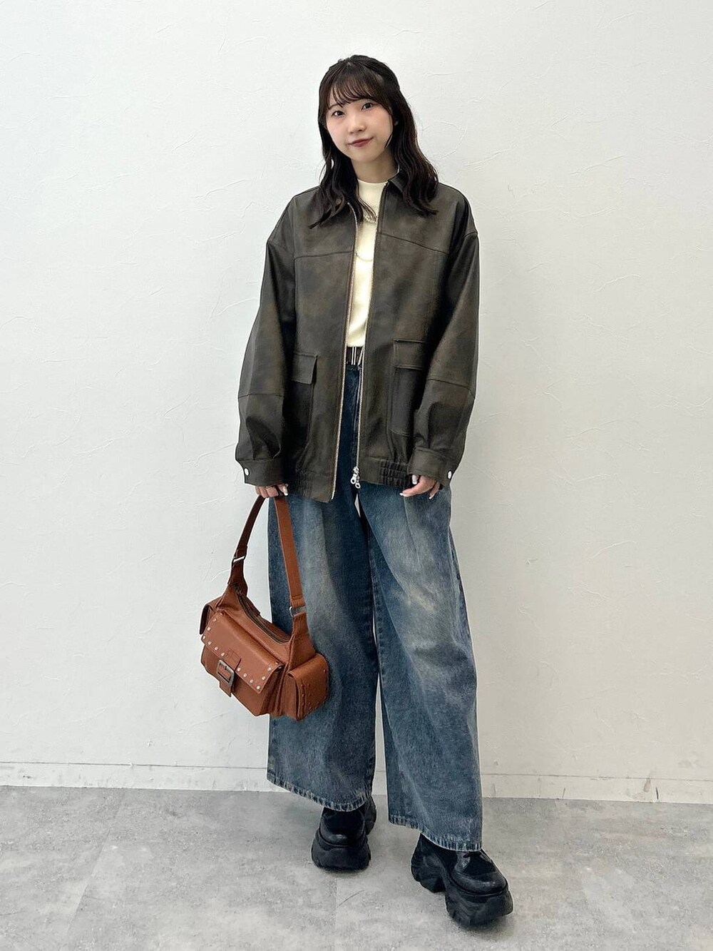 ブラック系のブーツ、ブルー系のデニムパンツ、ホワイト系のニット/セーターを着用したレディースの夏コーディネートの4枚目の写真