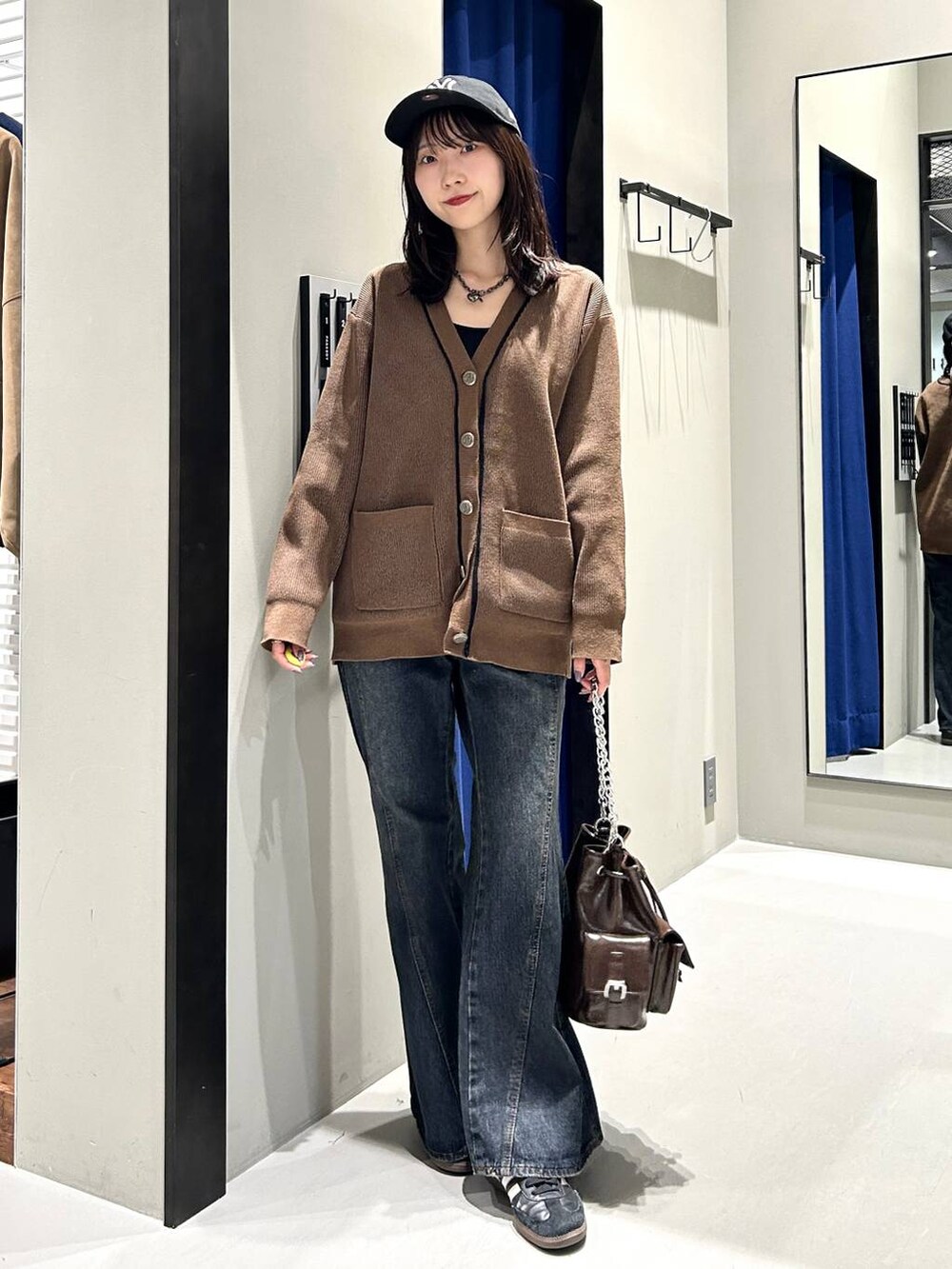 ブラック系のキャミソール、ブルー系のデニムパンツ、ブラウン系のショルダーバッグを着用したレディースの秋コーディネートの6枚目の写真