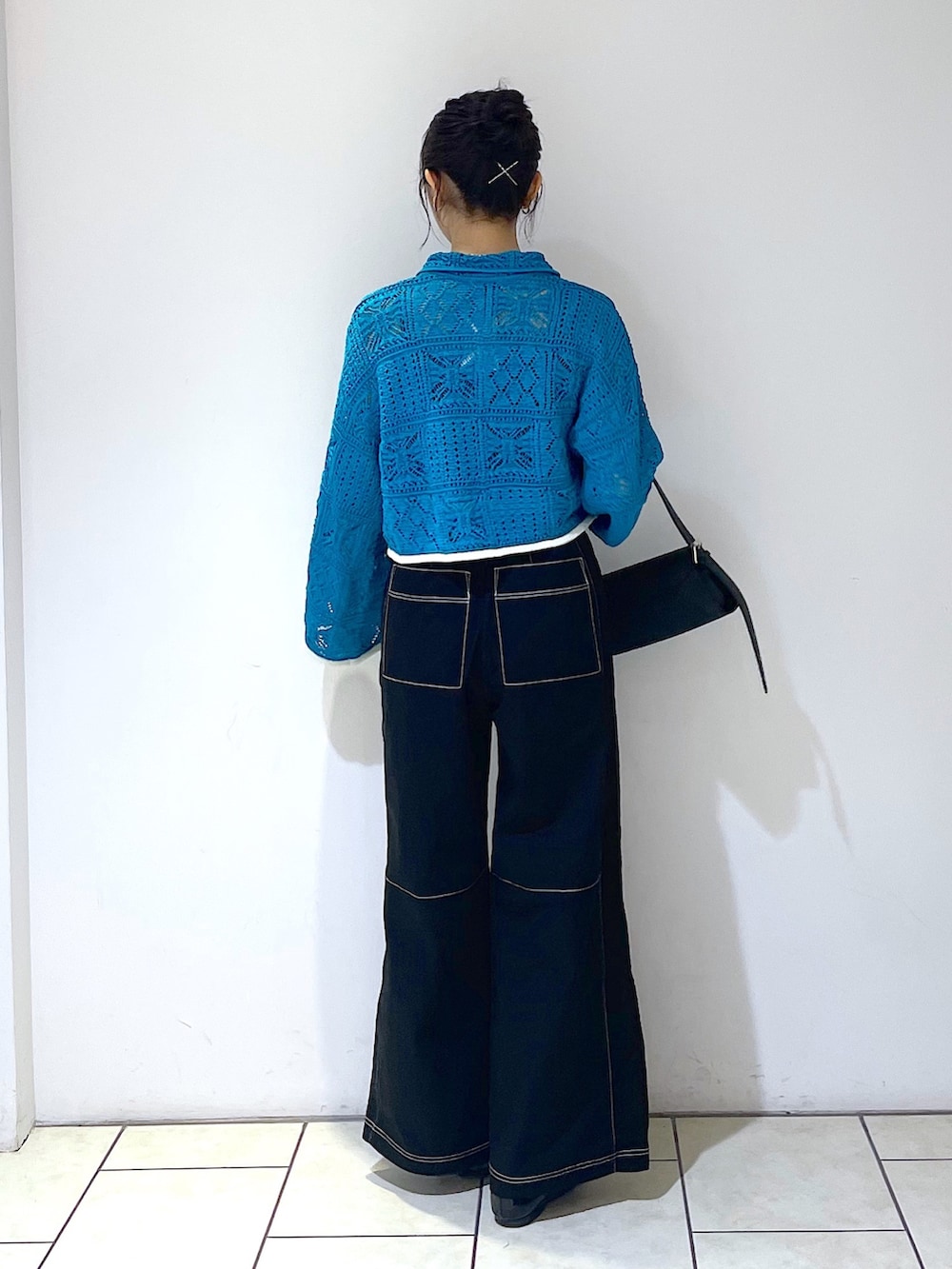 グリーン系のカーディガン/ボレロ、グレー系のタンクトップ、ブラック系のトートバッグを着用したレディースの春コーディネートの3枚目の写真