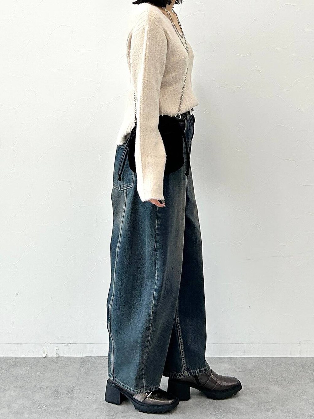 ベージュ系のニット/セーター、その他のブーツ、ブラック系のハンドバッグを着用したレディースの冬コーディネートの4枚目の写真