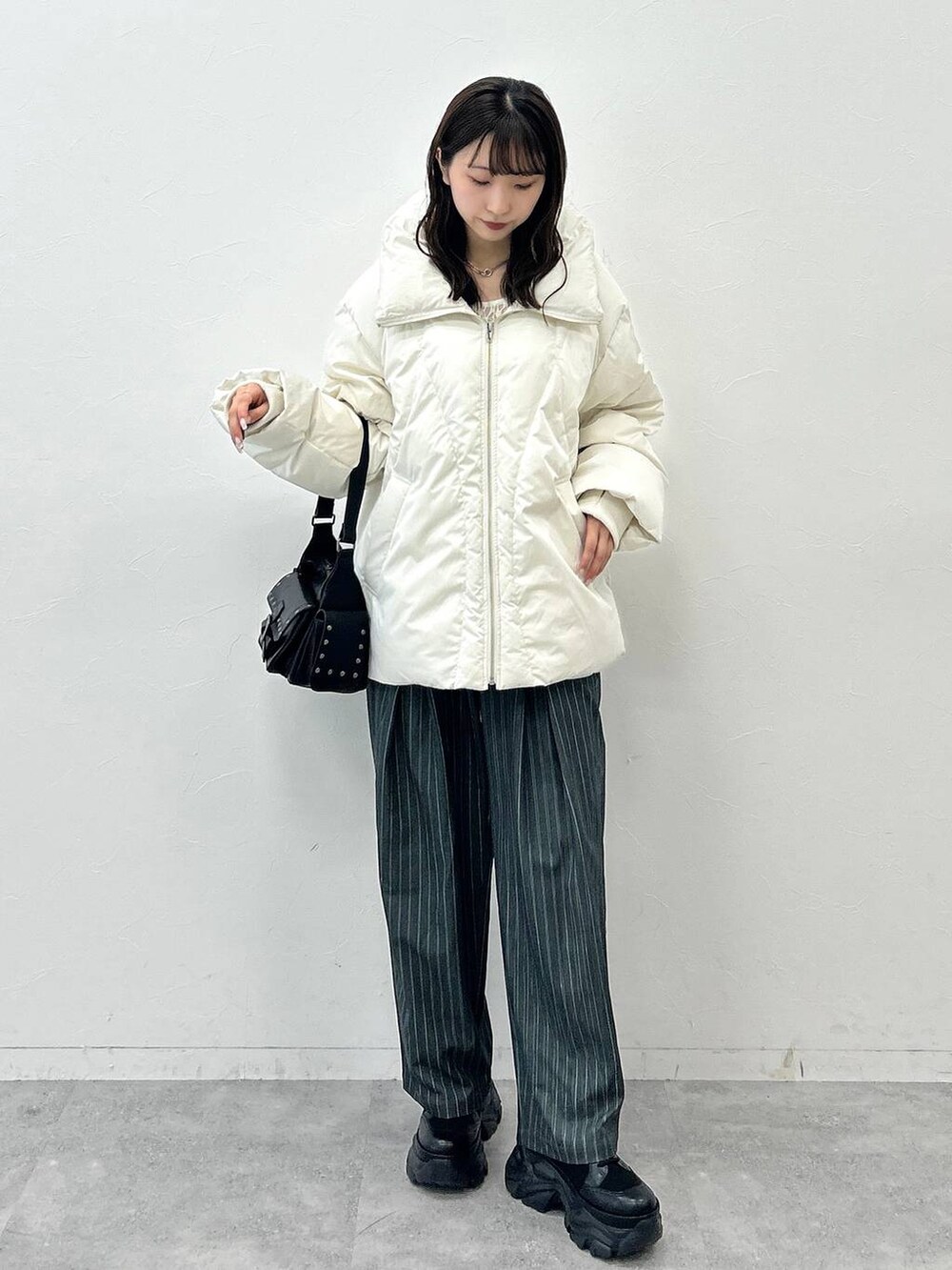 ブラック系のショルダーバッグ、ホワイト系のブルゾン、ホワイト系のTシャツ/カットソーを着用したレディースの秋コーディネートの5枚目の写真