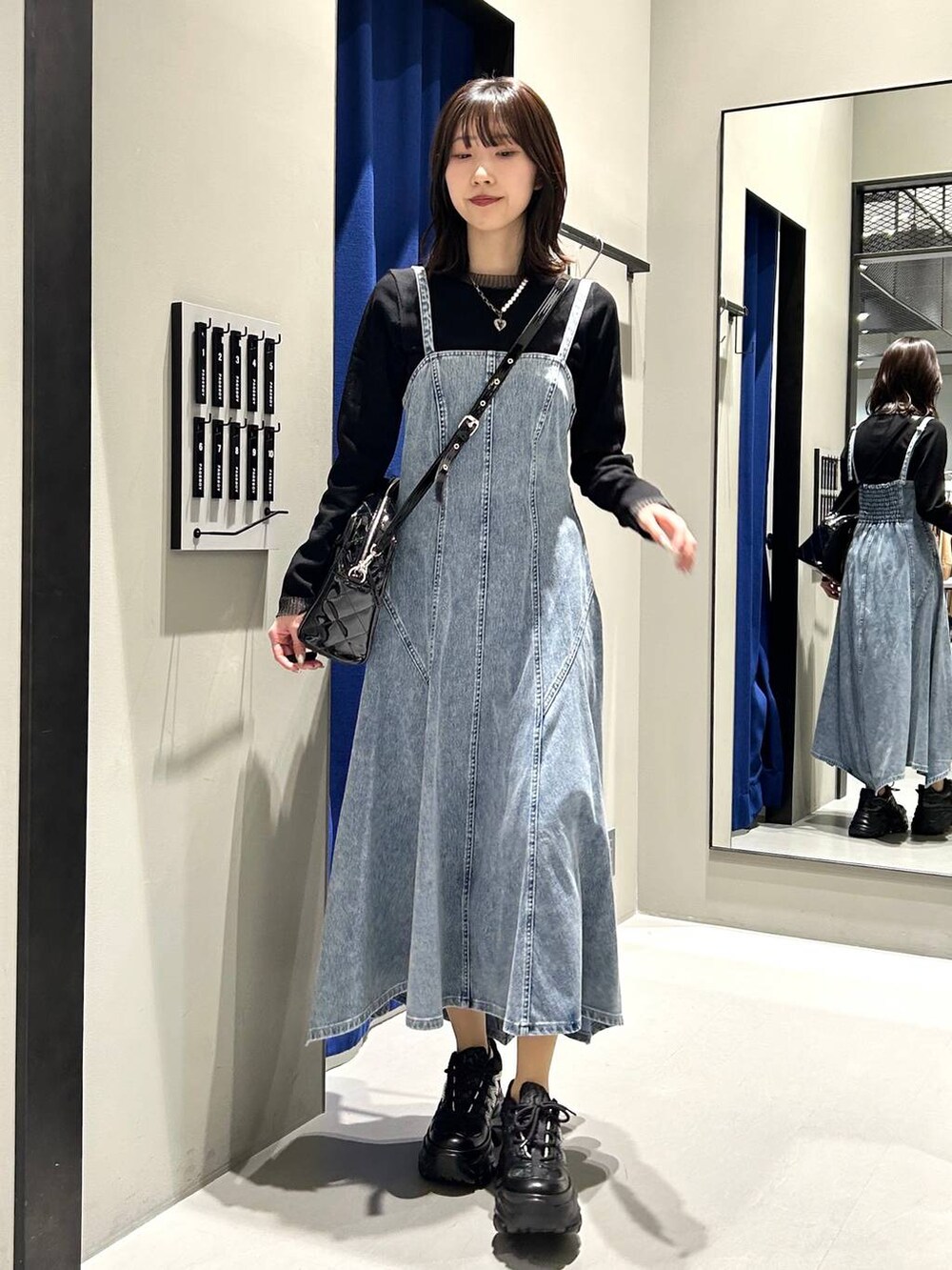 ブラック系のスニーカー、ブラック系のボストンバッグ、ブラック系のニット/セーターを着用したレディースの冬コーディネートの4枚目の写真