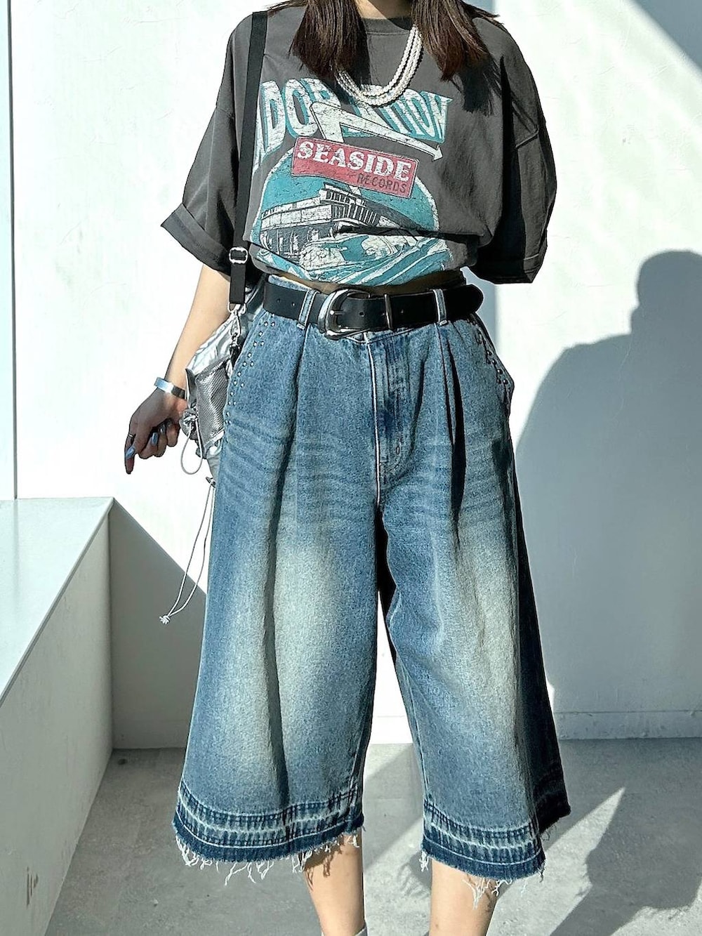 シルバー系のバックパック/リュック、グレー系のTシャツ/カットソー、ブルー系のデニムパンツを着用したレディースの夏コーディネートの5枚目の写真