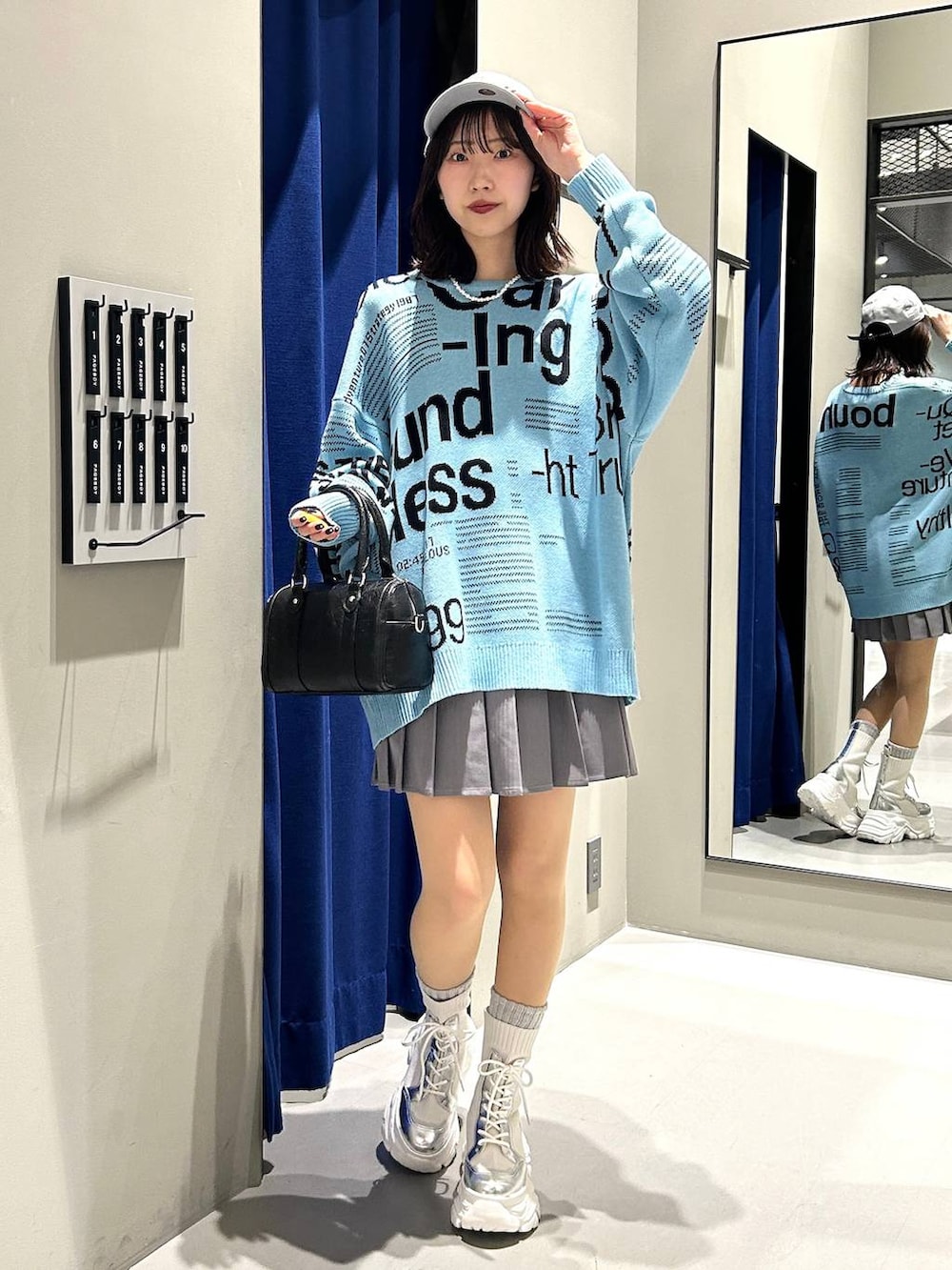 ホワイト系のブーツ、グレー系のその他パンツ、ブラック系のボストンバッグを着用したレディースの冬コーディネートの2枚目の写真