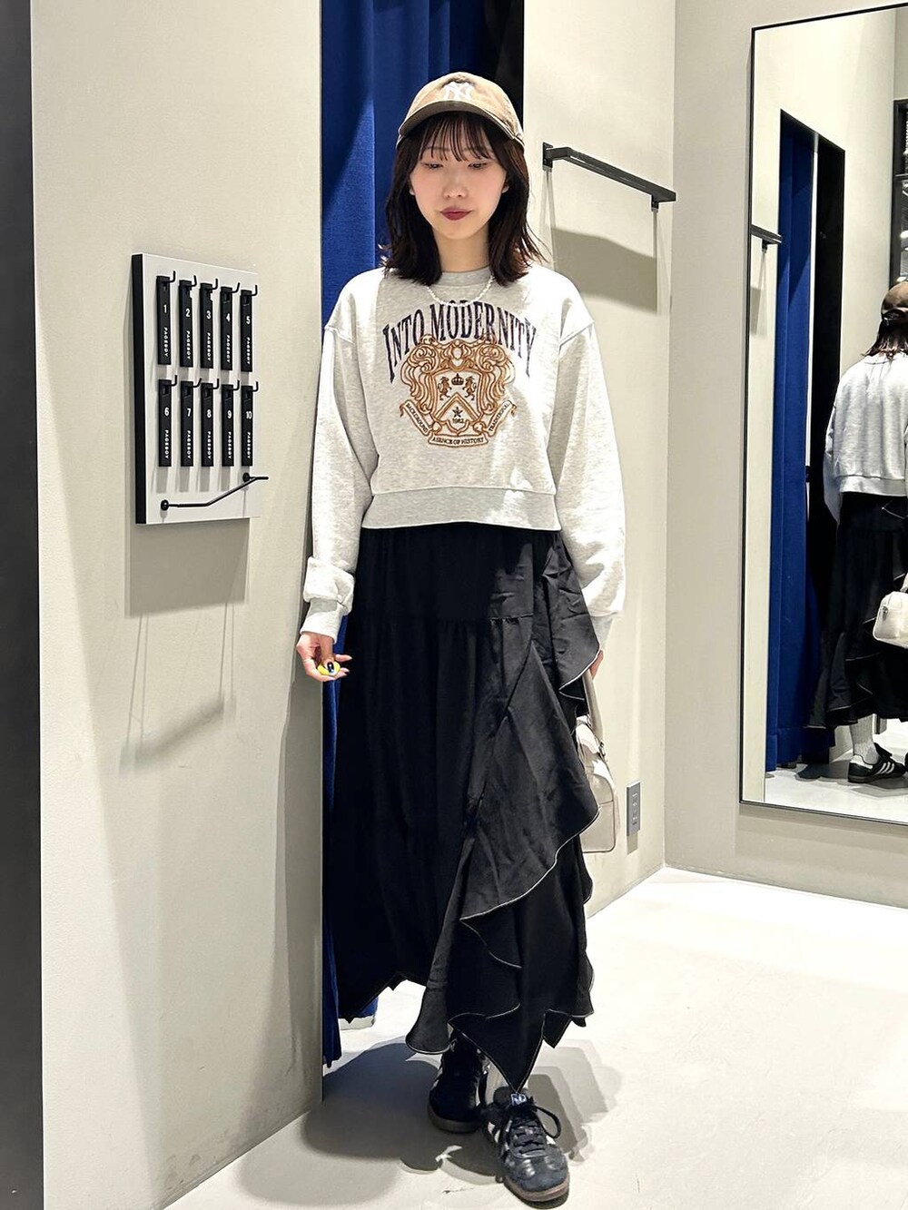 ブラック系のスカート、ホワイト系のボストンバッグ、グレー系のスウェットを着用したレディースの冬コーディネートの5枚目の写真