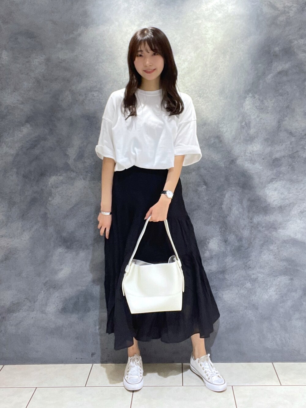 ブラック系のスカート、ホワイト系のTシャツ/カットソー、ホワイト系のショルダーバッグを着用したレディースの夏コーディネートの2枚目の写真