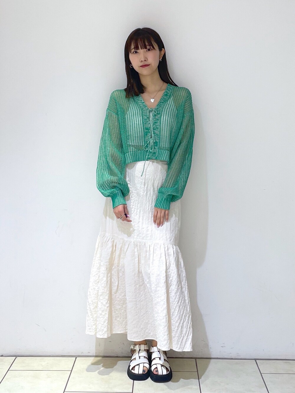 ホワイト系のキャミソール、ホワイト系のスカート、ホワイト系のサンダルを着用したレディースの春コーディネートの2枚目の写真