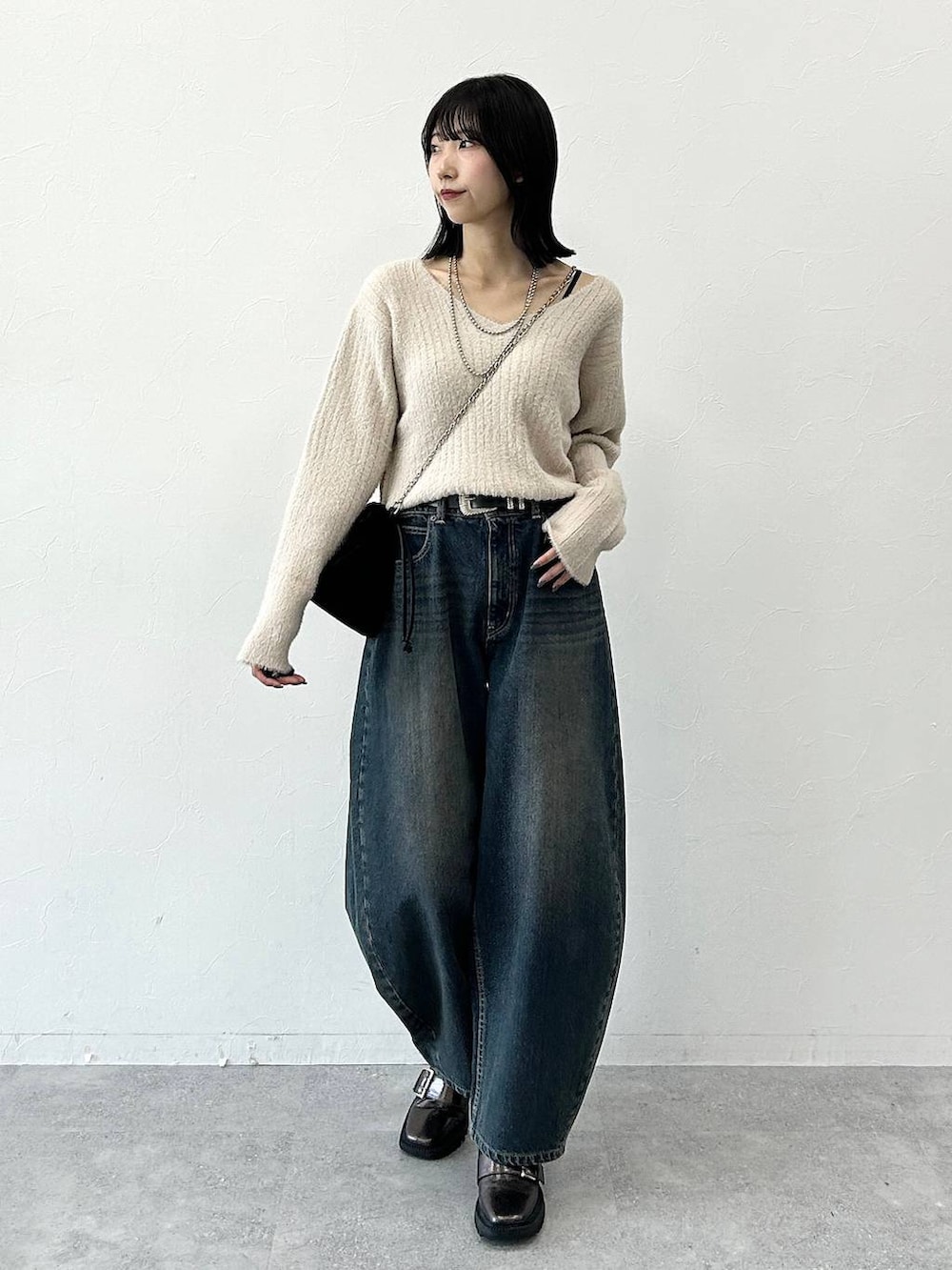 ベージュ系のニット/セーター、その他のブーツ、ブラック系のハンドバッグを着用したレディースの冬コーディネートの2枚目の写真