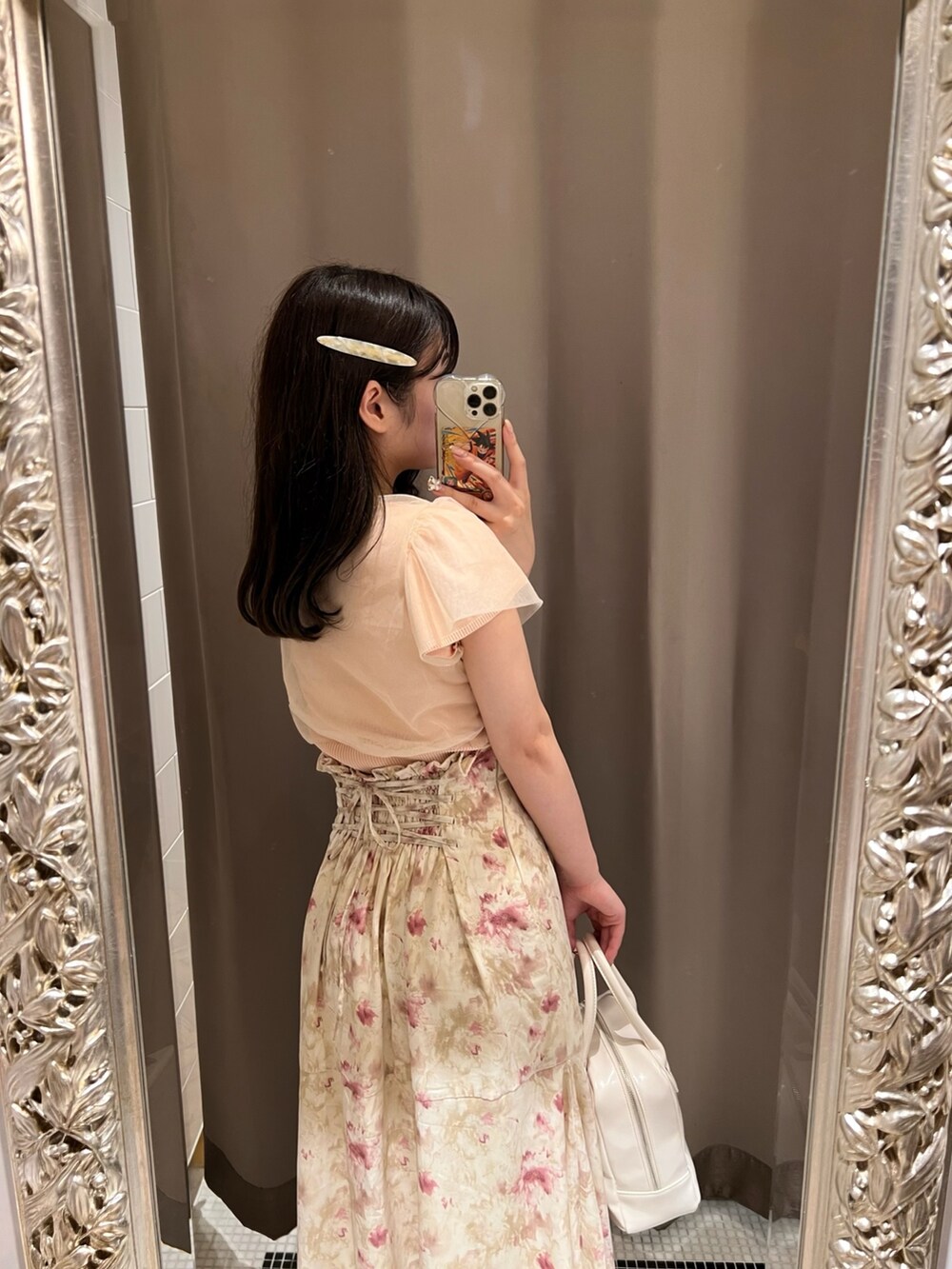 ピンク系のニット/セーター、ベージュ系のスカートを着用したレディースの夏コーディネートの3枚目の写真