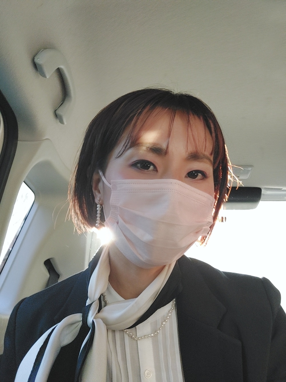 ブラック系のスカート、ブラック系のテーラードジャケット、ホワイト系のシャツ/ブラウスを着用したレディースの春コーディネートの3枚目の写真