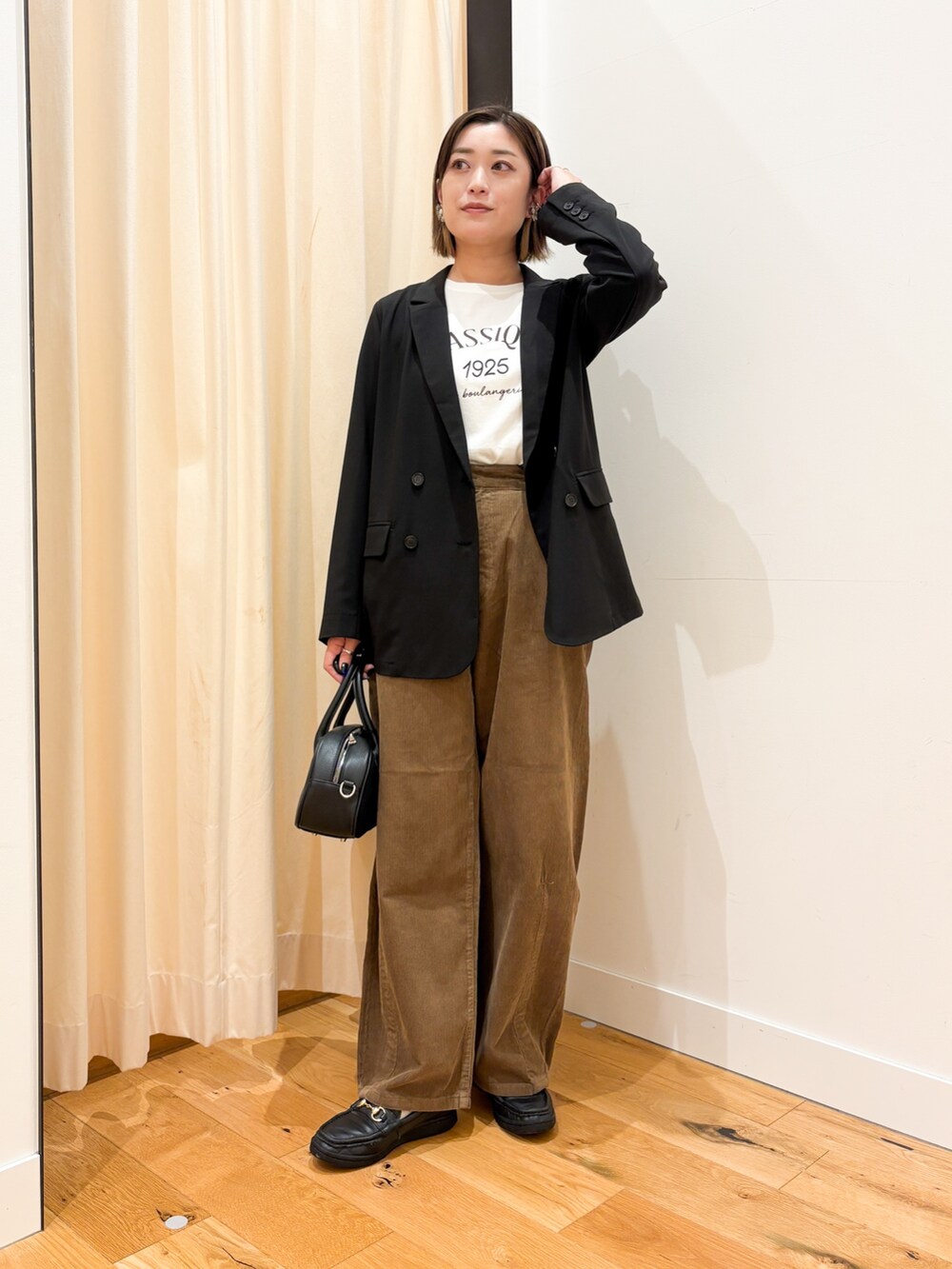 ブラック系のその他アウター、ホワイト系のTシャツ/カットソー、ブラック系のショルダーバッグを着用したレディースの秋コーディネートの4枚目の写真