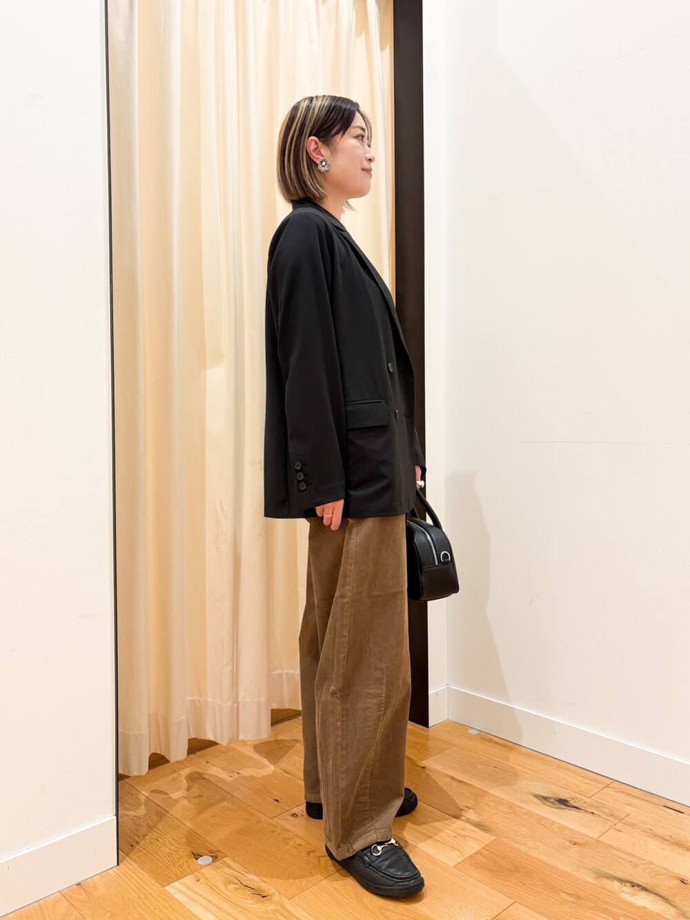 ブラック系のその他アウター、ホワイト系のTシャツ/カットソー、ブラック系のショルダーバッグを着用したレディースの秋コーディネートの3枚目の写真