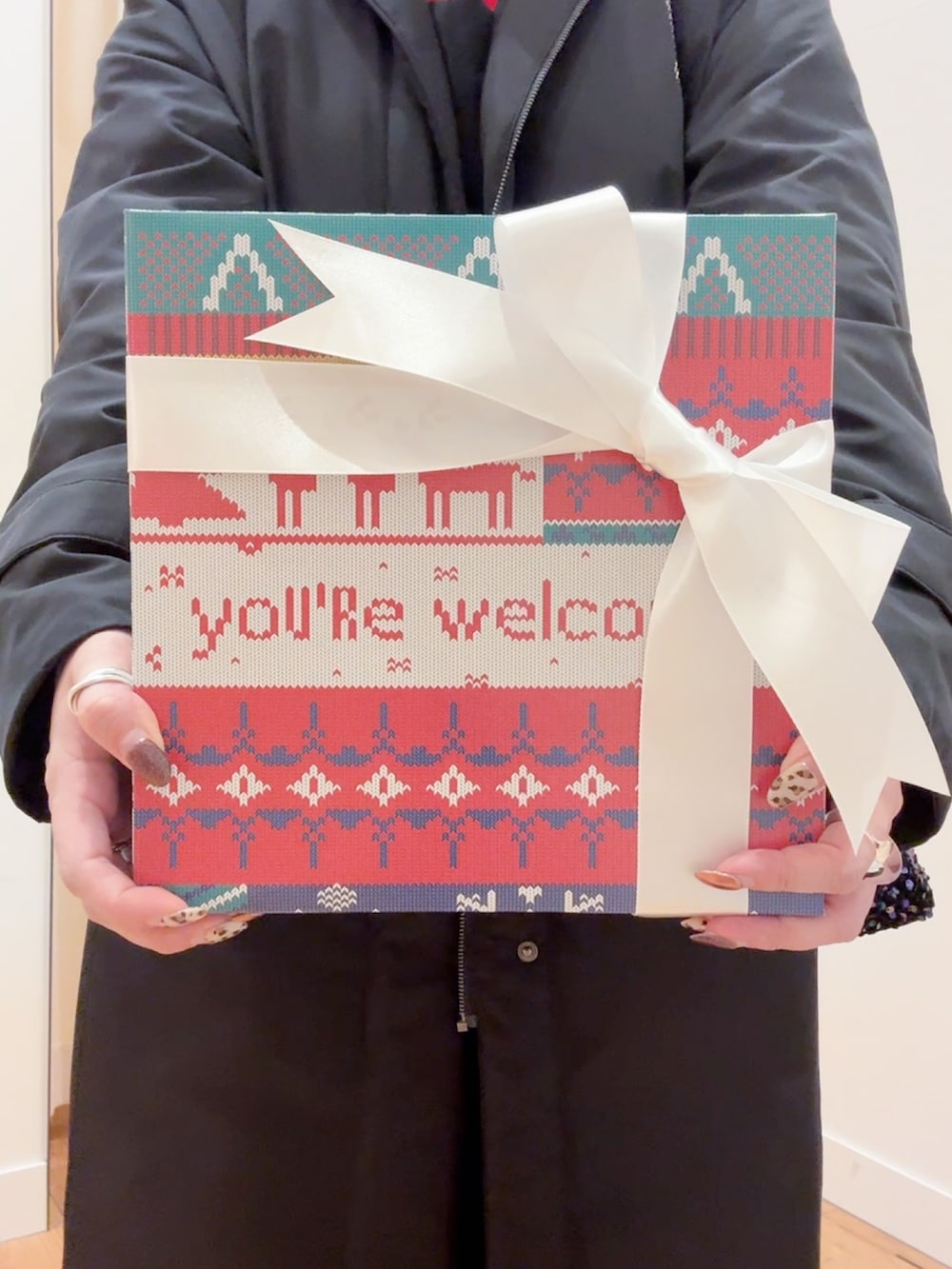 レッド系のニット/セーター、ブラック系のダウンジャケット/コート、ブラック系のサロペット/オーバーオールを着用したレディースの秋コーディネートの2枚目の写真