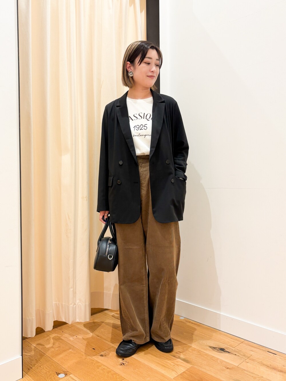 ブラック系のその他アウター、ホワイト系のTシャツ/カットソー、ブラック系のショルダーバッグを着用したレディースの秋コーディネートの5枚目の写真