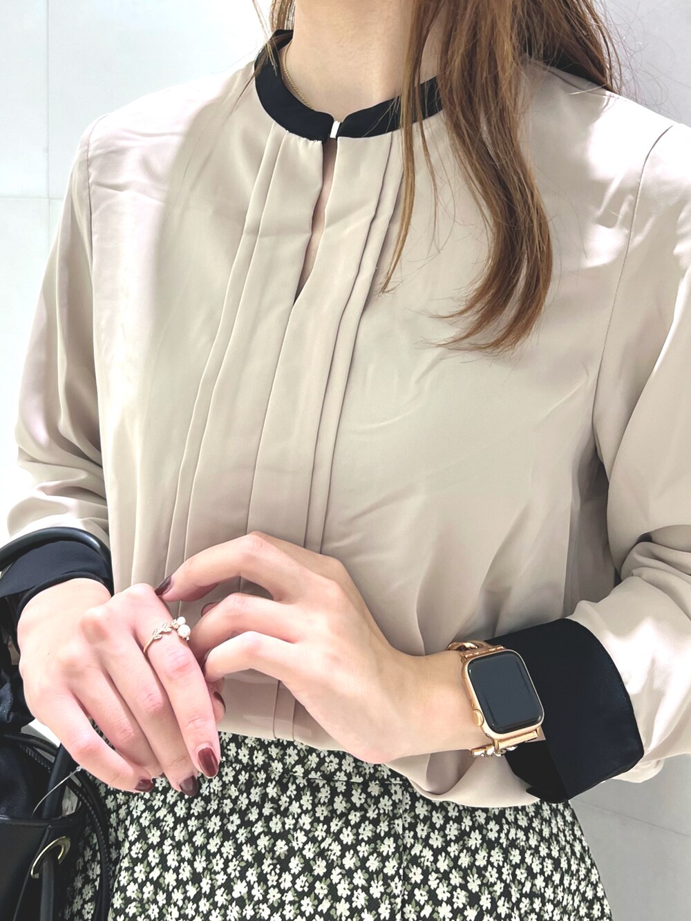 ベージュ系のシャツ/ブラウス、ブラック系のスカート、ブラウン系のハンドバッグを着用したレディースの秋コーディネートの2枚目の写真