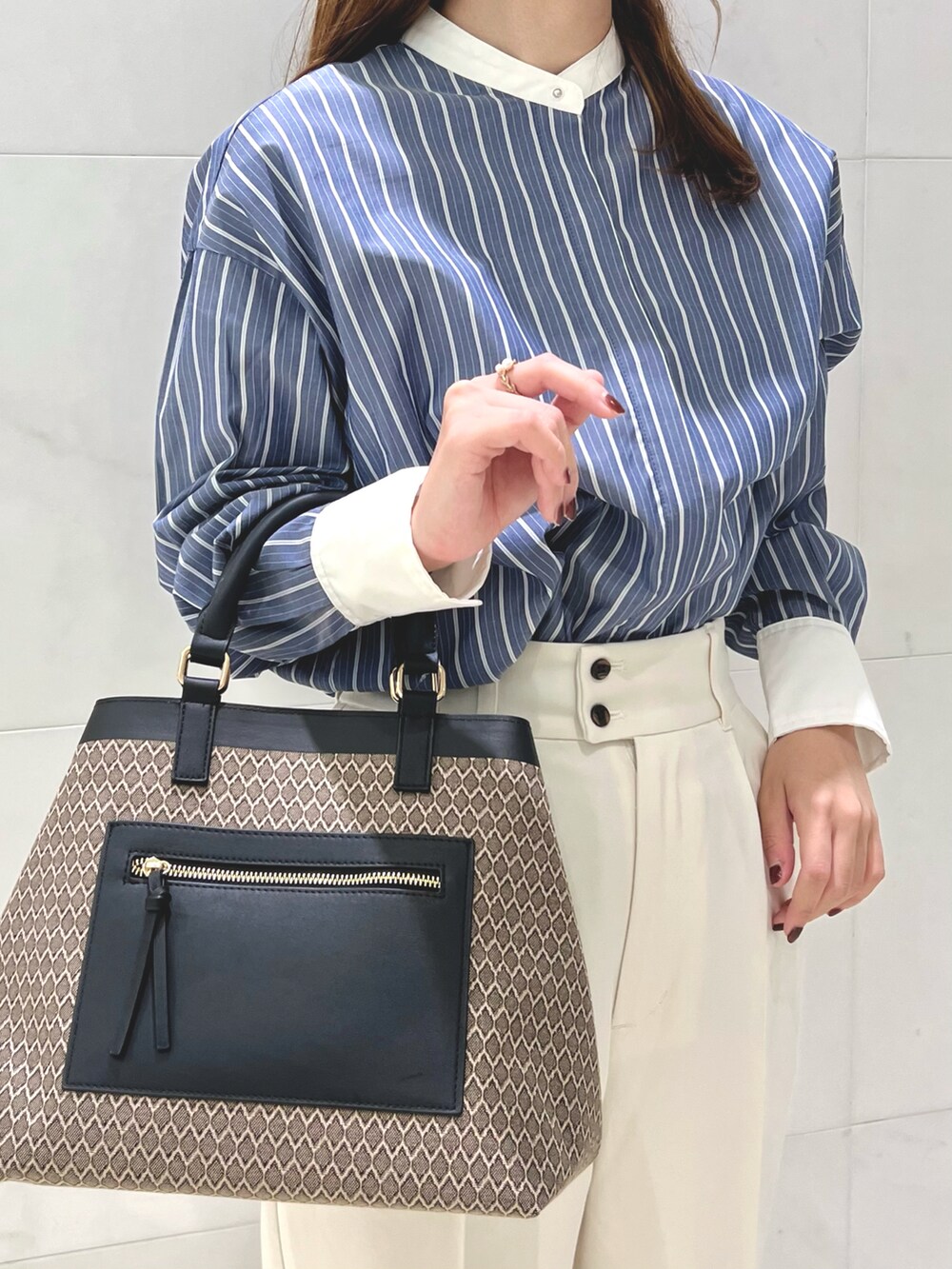 ブルー系のシャツ/ブラウス、ホワイト系のその他パンツ、ブラウン系のハンドバッグを着用したレディースの秋コーディネートの2枚目の写真