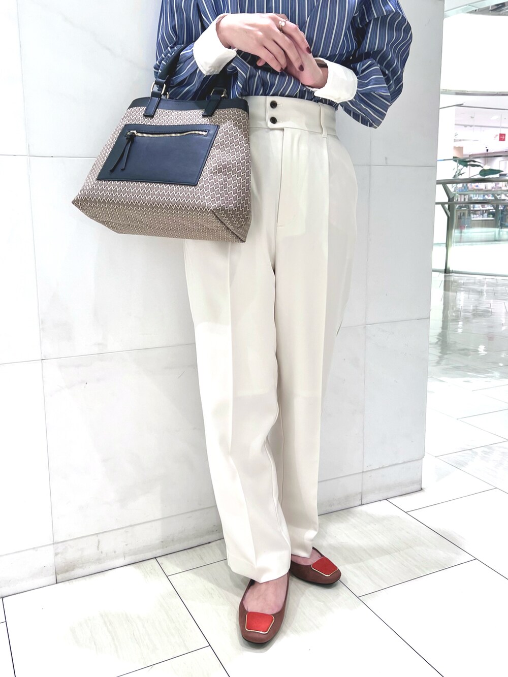 ブルー系のシャツ/ブラウス、ホワイト系のその他パンツ、ブラウン系のハンドバッグを着用したレディースの秋コーディネートの3枚目の写真