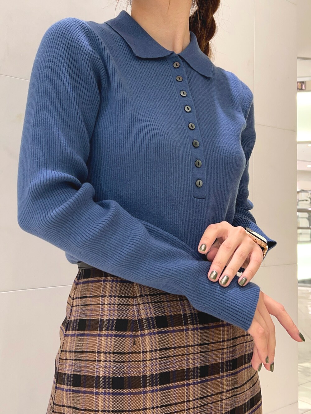 ブルー系のニット/セーター、ブラウン系のスカート、ブラック系のブーツを着用したレディースの秋コーディネートの2枚目の写真