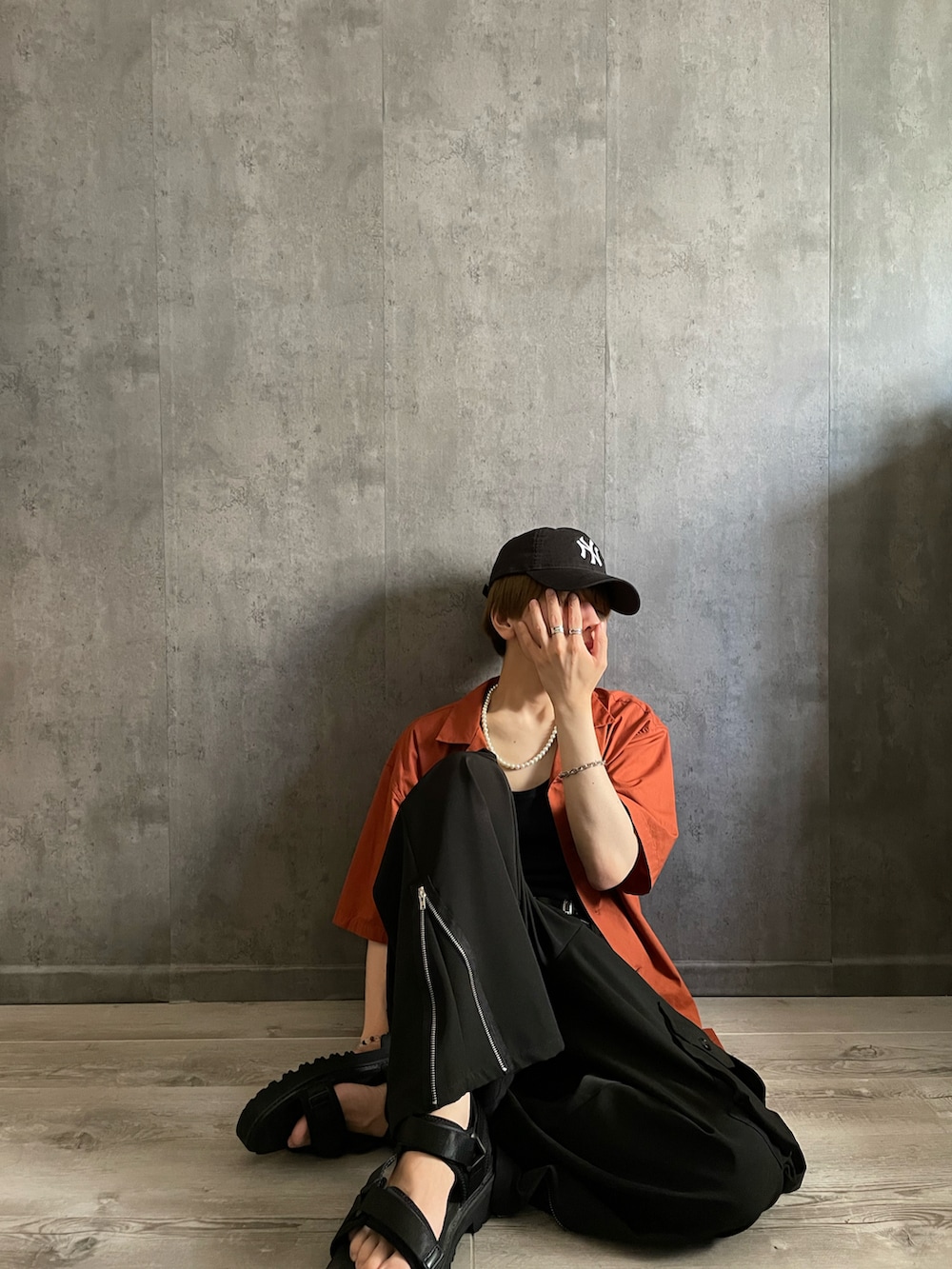 ブラック系のカーゴパンツ、ブラック系のタンクトップ、オレンジ系のシャツ/ブラウスを着用したメンズの夏コーディネートの3枚目の写真