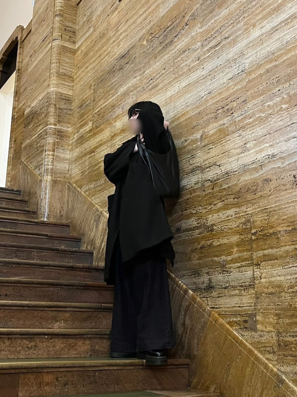 ブラック系のトートバッグ、ブラック系のトレンチコート、ブラック系のその他パンツを着用したメンズの冬コーディネートの3枚目の写真