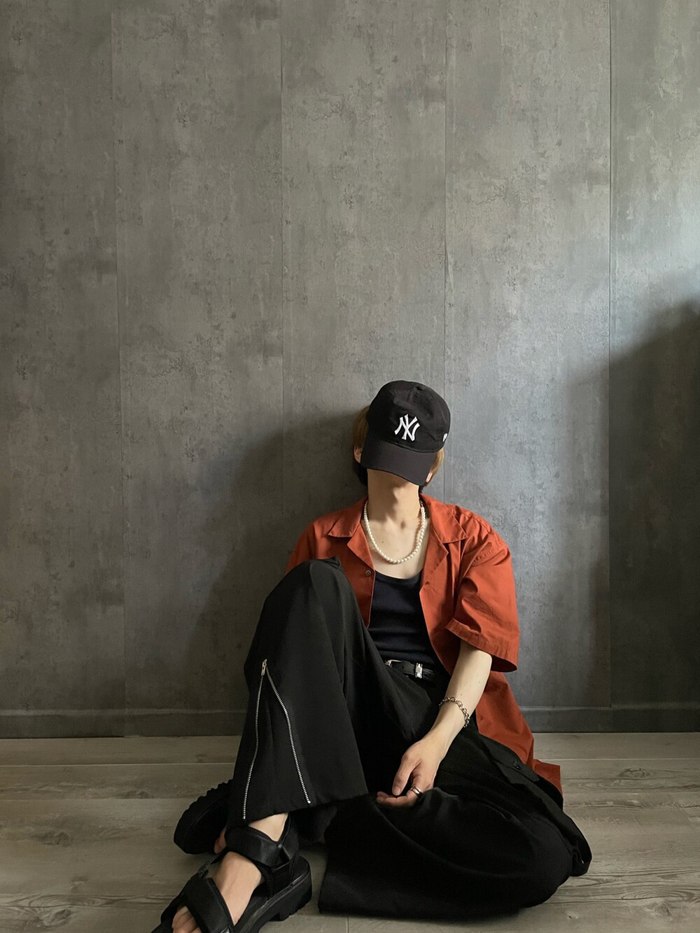 ブラック系のカーゴパンツ、ブラック系のタンクトップ、オレンジ系のシャツ/ブラウスを着用したメンズの夏コーディネートの4枚目の写真