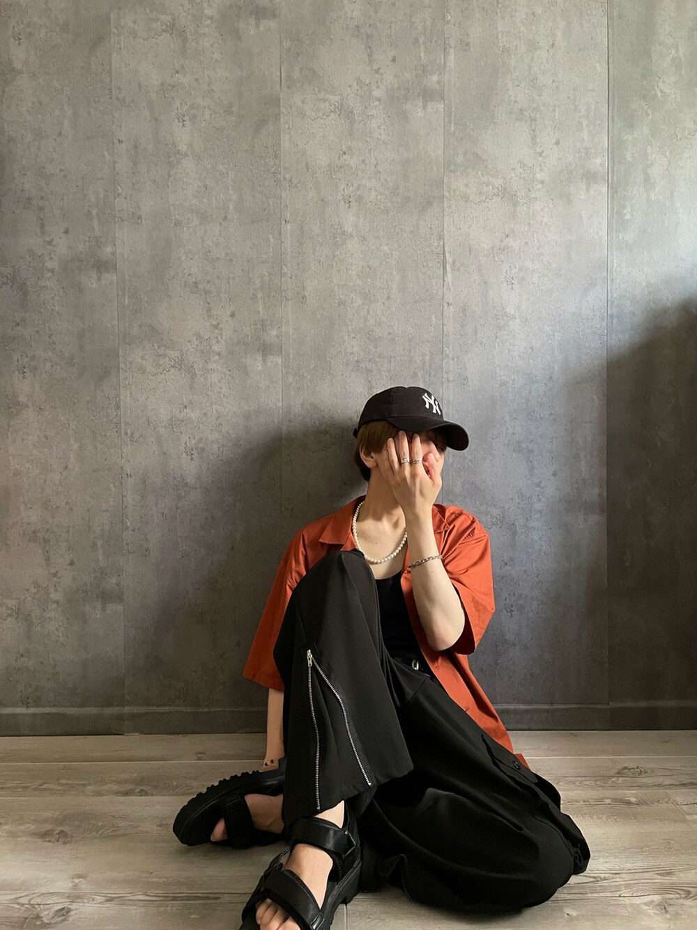 ブラック系のカーゴパンツ、ブラック系のタンクトップ、オレンジ系のシャツ/ブラウスを着用したメンズの夏コーディネートの2枚目の写真