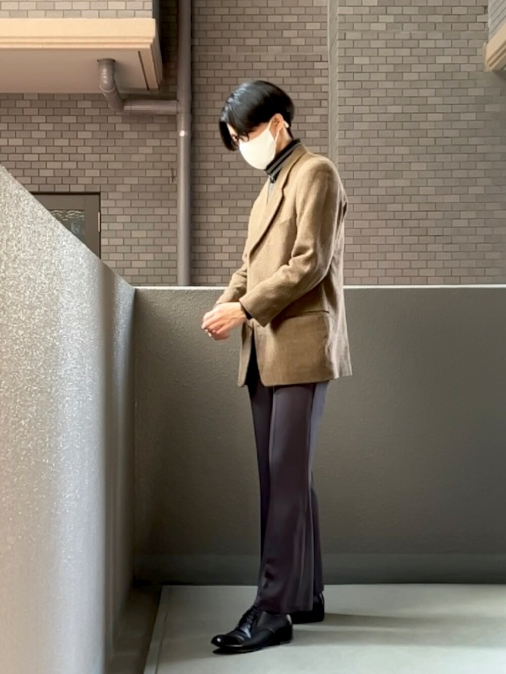 グレー系のスラックス、ブラック系のドレスシューズ、ブラウン系のテーラードジャケットを着用したメンズの春コーディネートの2枚目の写真