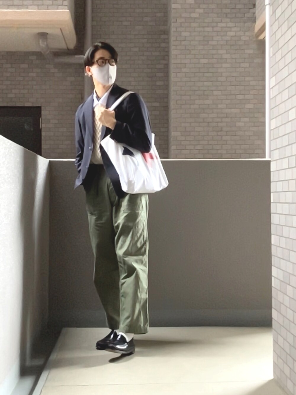 ベージュ系のベスト、ブルー系のテーラードジャケット、ホワイト系のポロシャツを着用したメンズの春コーディネートの2枚目の写真