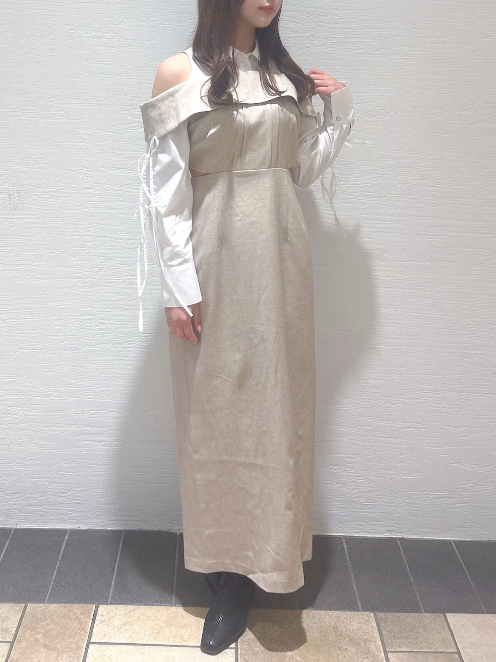 ベージュ系のワンピースを着用したレディースの冬コーディネートの2枚目の写真